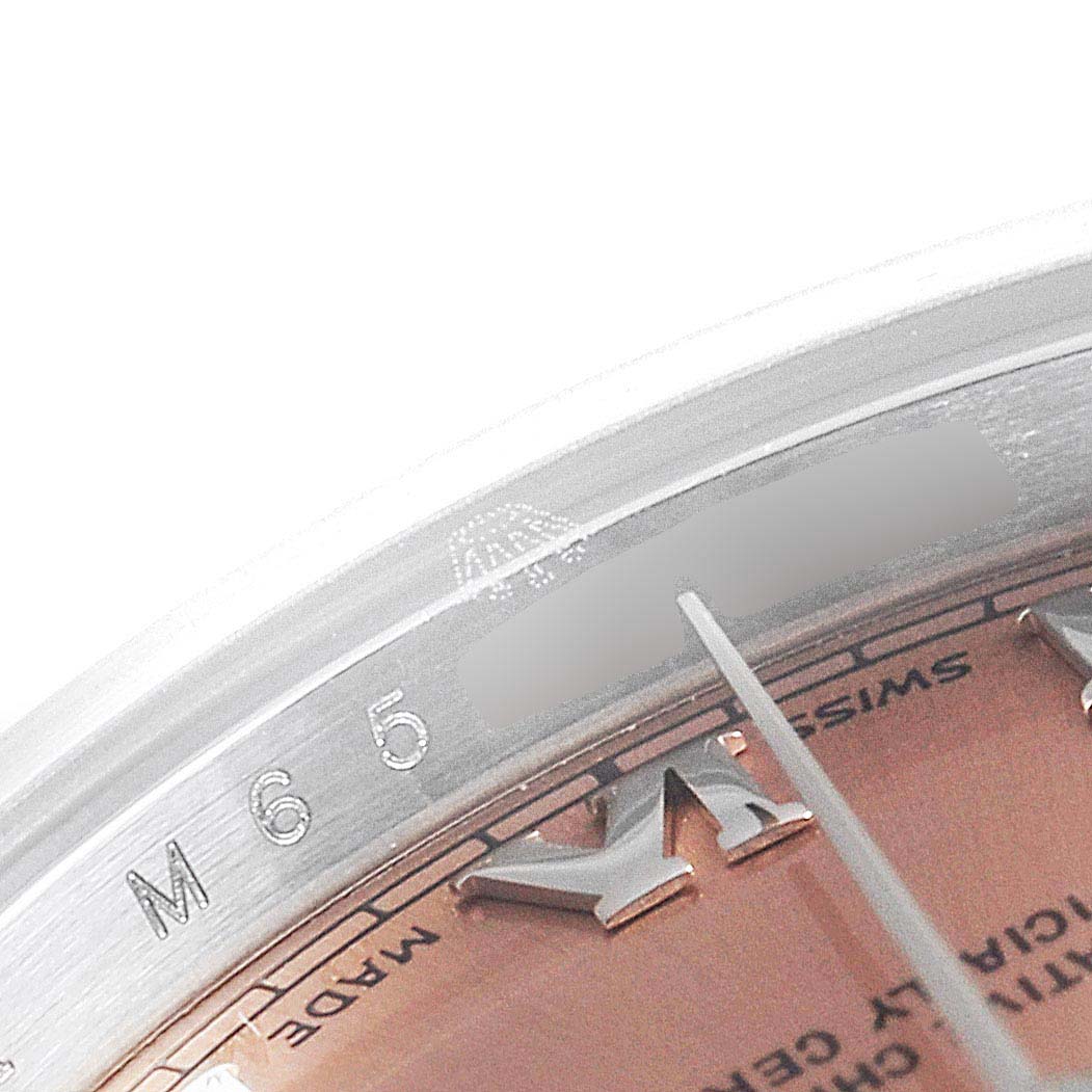 This close-up of the Rolex Datejust 179160 Women's Stainless Steel Pink Dial 179160 Women's Stainless Steel Pink Dial watch features part of its dial, markers, and inner bezel with engravings.