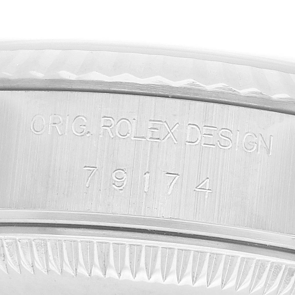 The image shows a close-up of the edge of a Rolex Datejust 79174 Women's Steel and Gold (two tone) Silver Dial watch, highlighting the engraved "ORIG. ROLEX DESIGN" and model number.