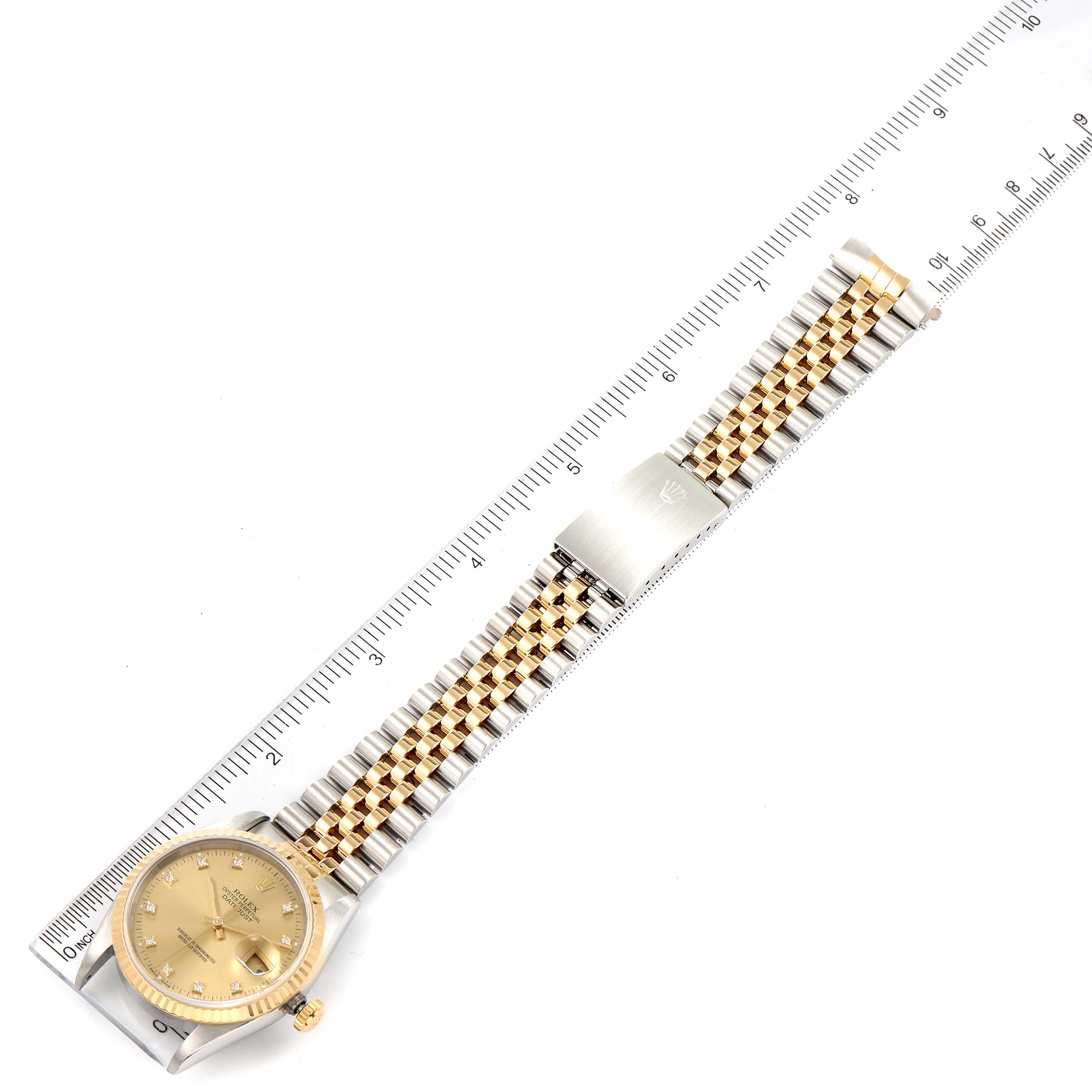 The Rolex Datejust 16233 Men's Steel and Gold (two tone) Champagne Dial 16233 Men's Steel and Gold (two tone) Champagne Dial watch is shown laid flat with its full bracelet, clasp, and case visible, alongside a measuring ruler.