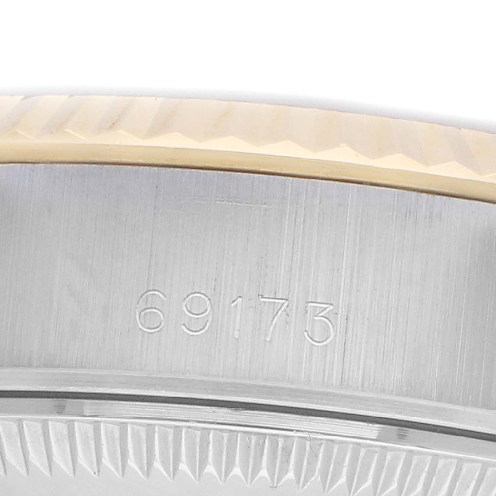 The image shows a close-up of the side of a Rolex Datejust 69173 Women
s Steel and Gold (two tone) Champagne Dial watch, focusing on the band and engraved model number.