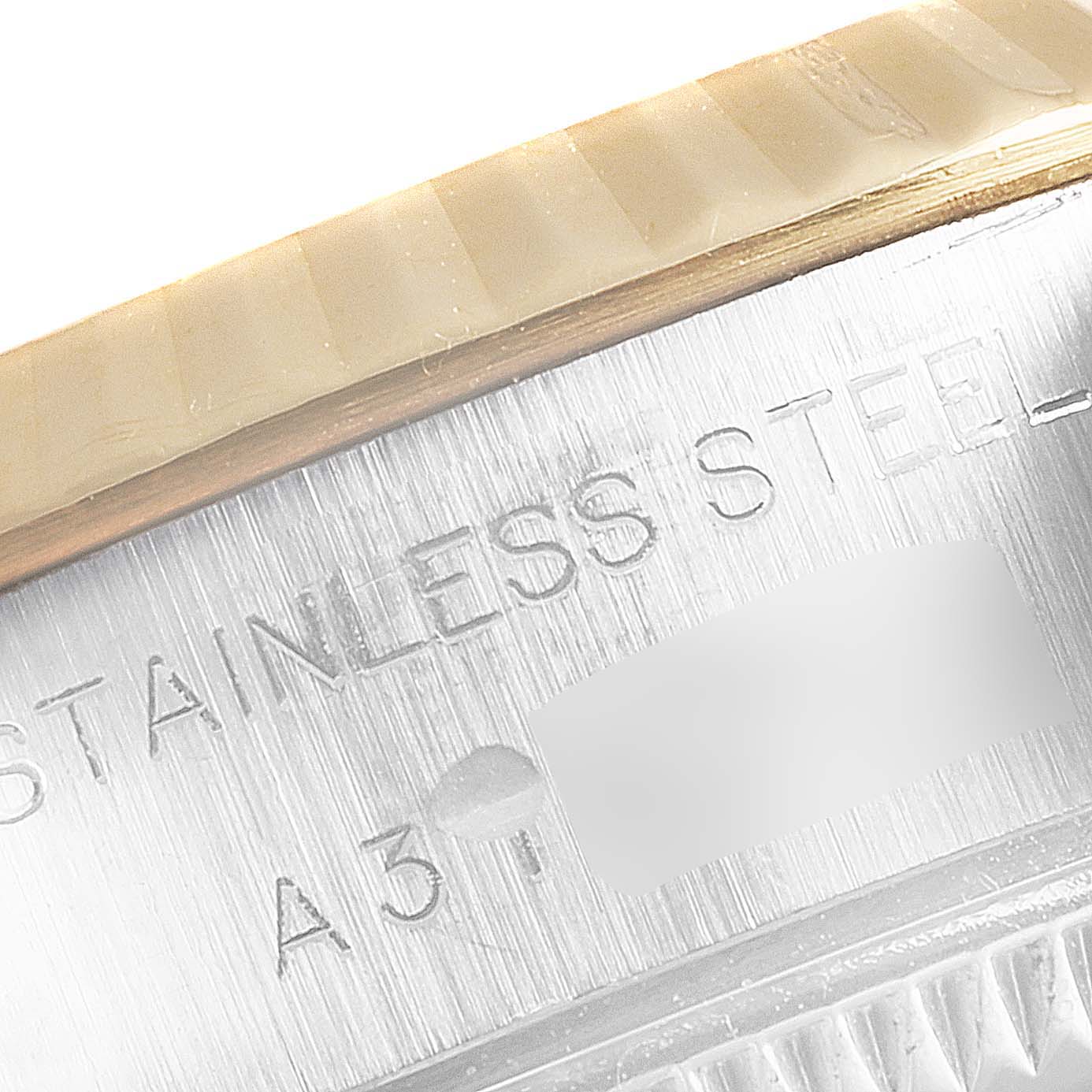 This close-up image shows part of the bezel and engraved text on the side of a Rolex Datejust 79173 Women's Steel and Gold (two tone) Champagne Dial 79173 Women's Steel and Gold (two tone) Champagne Dial watch, indicating it's stainless steel.