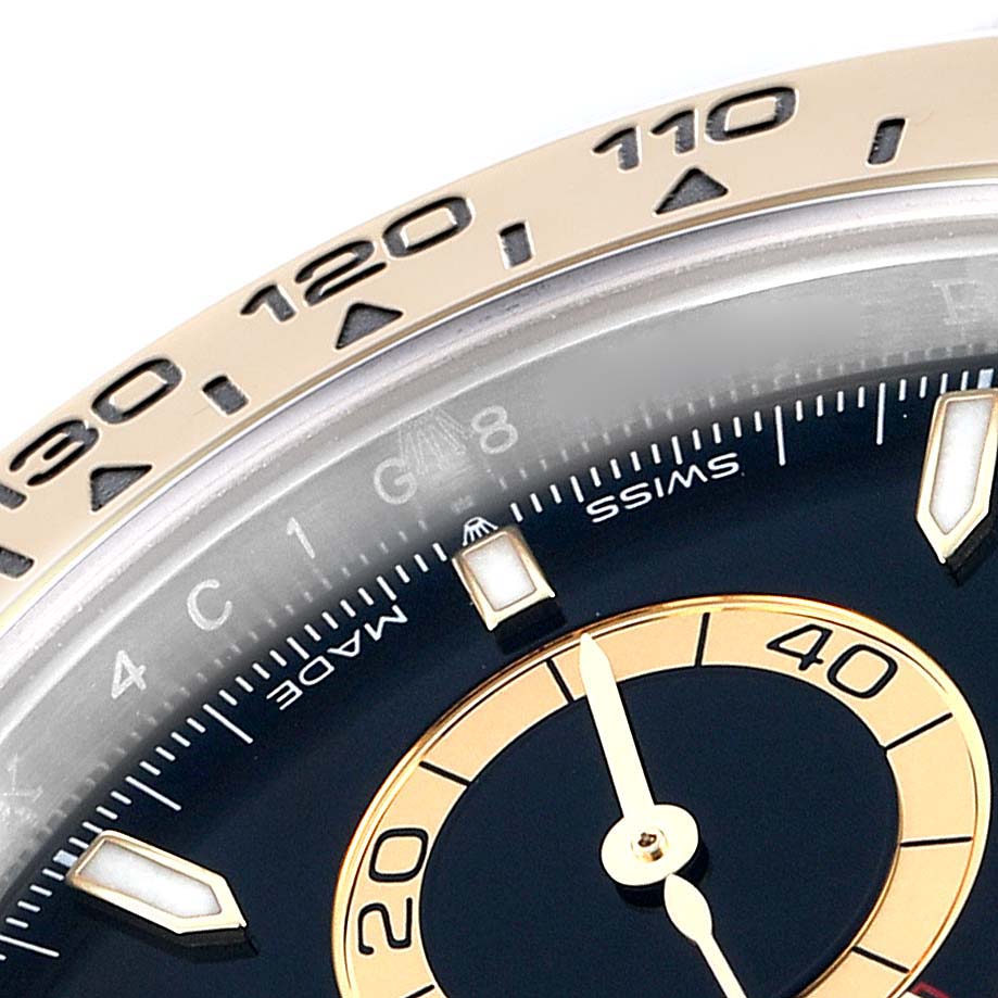 The image shows a close-up of the bezel and dial of a Rolex Daytona 126503 Men
s Steel and Gold (two tone) Black Dial watch, focusing on part of the tachymetric scale and markers.