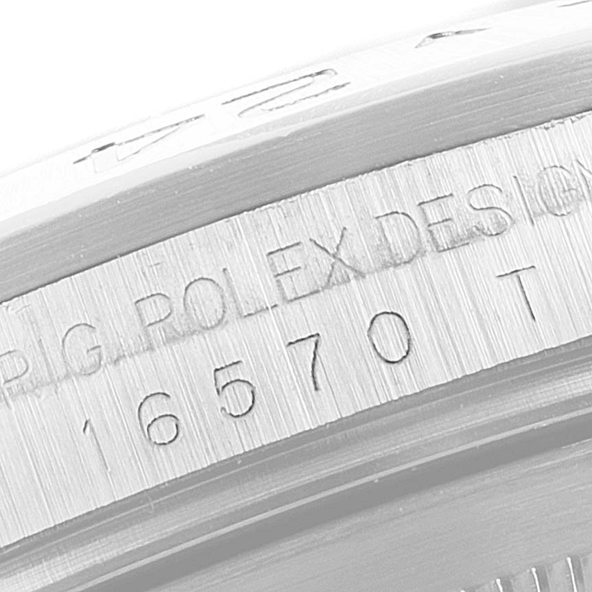 The image shows a close-up of the engraved bezel and case side of a Rolex Explorer 16570 Men
s Stainless Steel Black Dial watch.