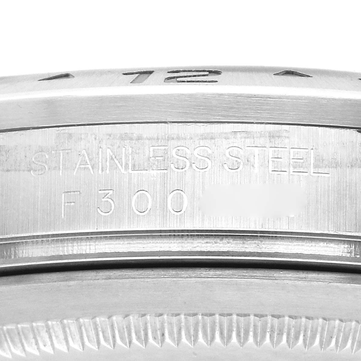 The image shows a close-up of the Rolex Explorer 16570 Men
s Stainless Steel Black Dial
s case side, highlighting the "STAINLESS STEEL" engraving.