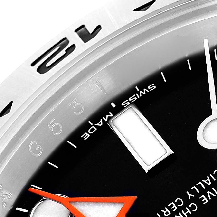 The image shows a close-up of the dial and bezel of a Rolex Explorer 216570 Men's Stainless Steel Black Dial, highlighting the hour markers and hands.