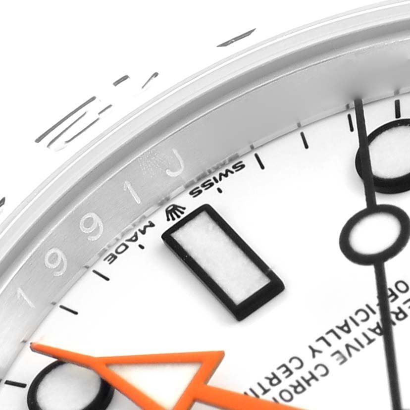 The image shows a close-up of the Rolex Explorer 226570 Men
s Stainless Steel White Dial
s dial, focusing on the bezel, markers, and orange hand.