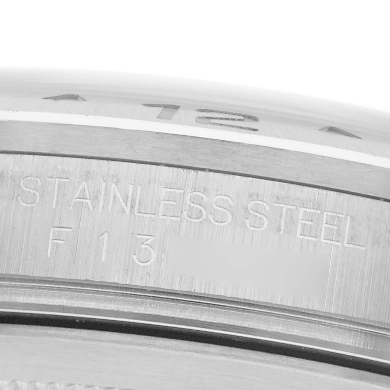 The image shows a close-up of the Rolex Explorer 16570 Men
s Stainless Steel White Dial
s stainless steel bezel with engraved markings.