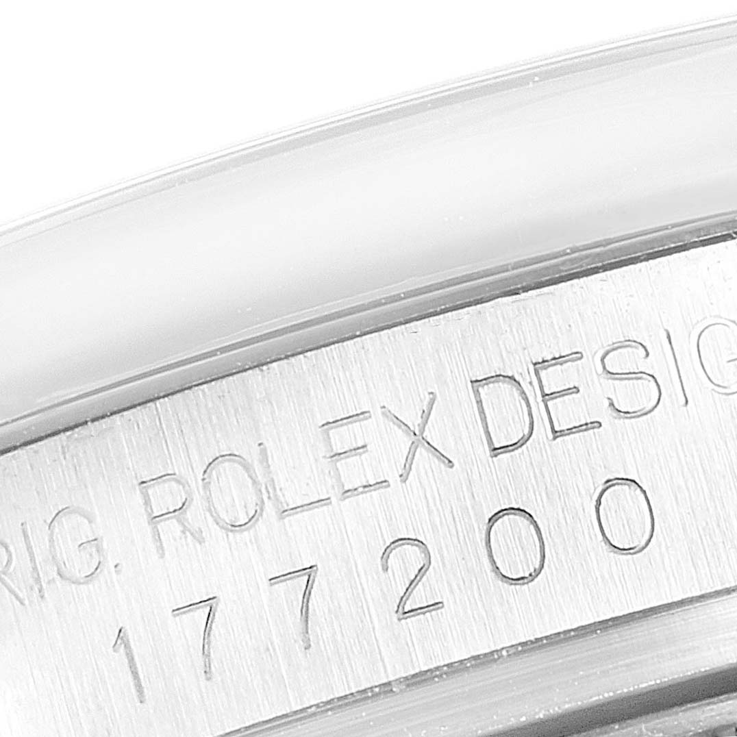 The image shows a close-up of the side case engraving of a Rolex Mid-Size 177200 Women
s Stainless Steel Silver Dial 177200 Women
s Stainless Steel Silver Dial model watch, displaying "ROLEX DESIGN" and the serial number.