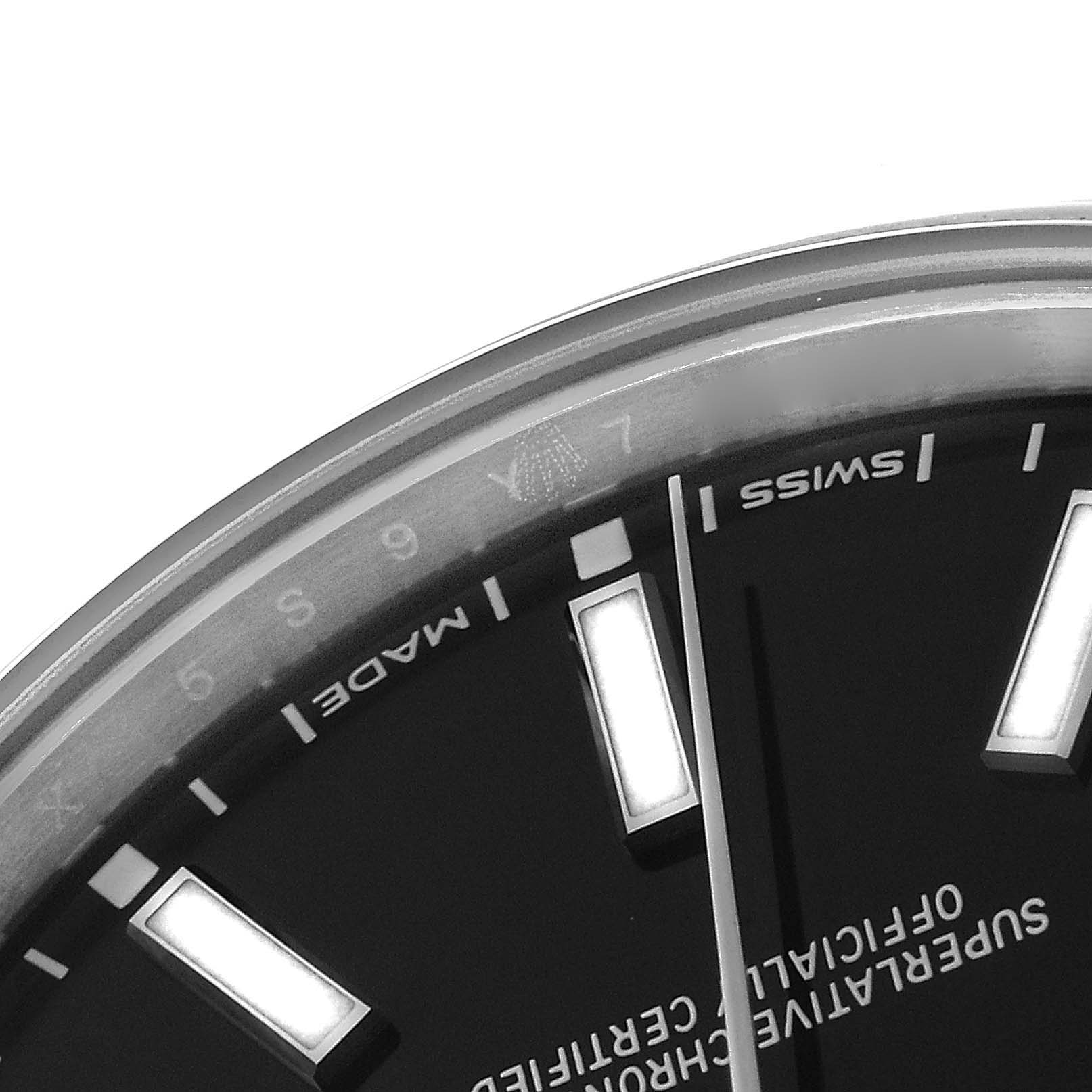 The image shows a close-up of the dial and bezel of a Rolex Oyster Perpetual 114300 Men's Stainless Steel Black Dial 114300 Men's Stainless Steel Black Dial watch.