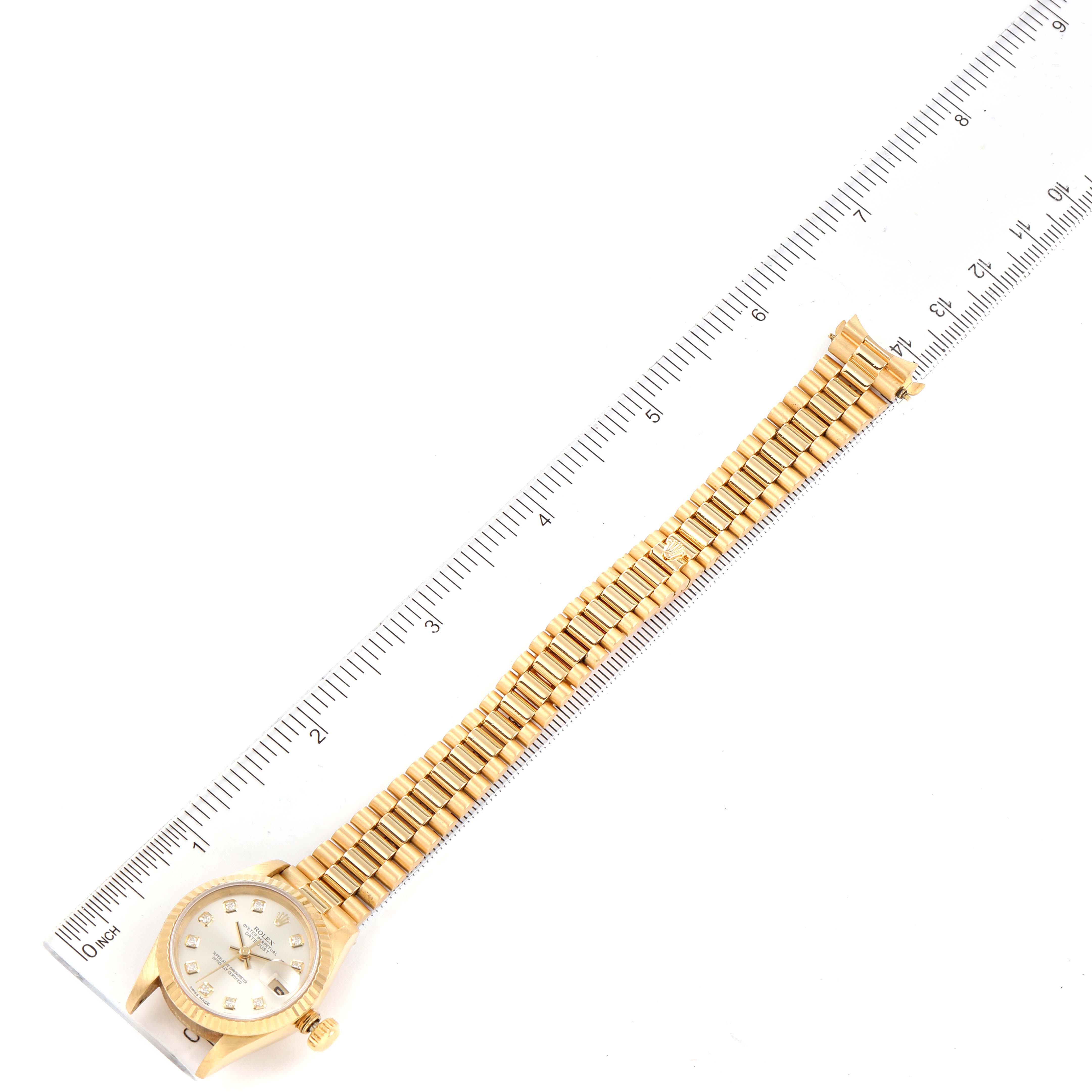 The Rolex President 69178 Women's Yellow Gold Silver Dial 69178 Women's Yellow Gold Silver Dial watch is displayed flat with the face and gold bracelet band shown alongside a ruler.