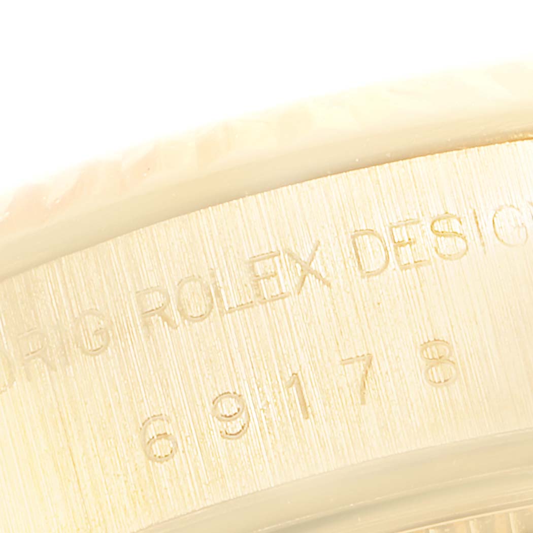 This is a close-up angle showing the engraved markings on the case of a Rolex President 69178 Women's Yellow Gold Silver Dial 69178 Women's Yellow Gold Silver Dial model watch.