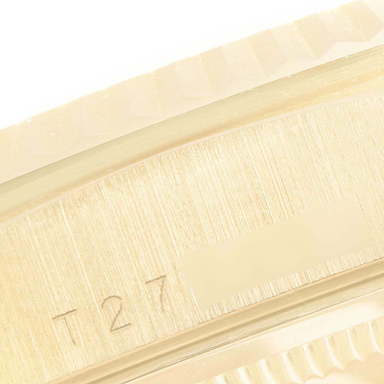 This close-up shot shows the engraved serial number and part of the fluted bezel on a Rolex President 18238 Men's Yellow Gold Mother of Pearl Dial 18238 Men's Yellow Gold Mother of Pearl Dial model watch.