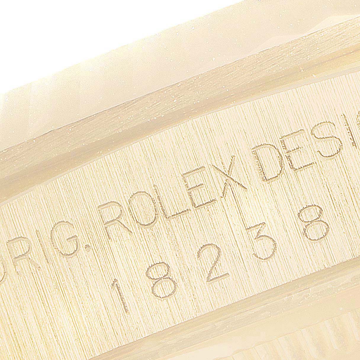 This image shows an engraved section of the bezel of a Rolex President 18238 Men's Yellow Gold Champagne Dial 18238 Men's Yellow Gold Champagne Dial model watch.