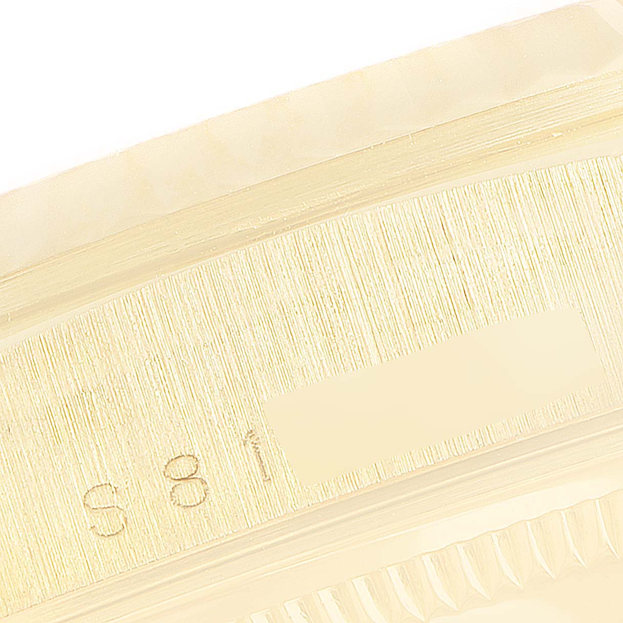 This image shows a close-up of the side of a Rolex President 18238 Men
s Yellow Gold Champagne Dial 18238 Men
s Yellow Gold Champagne Dial model watch, highlighting the engraved serial numbers and part of the bezel.