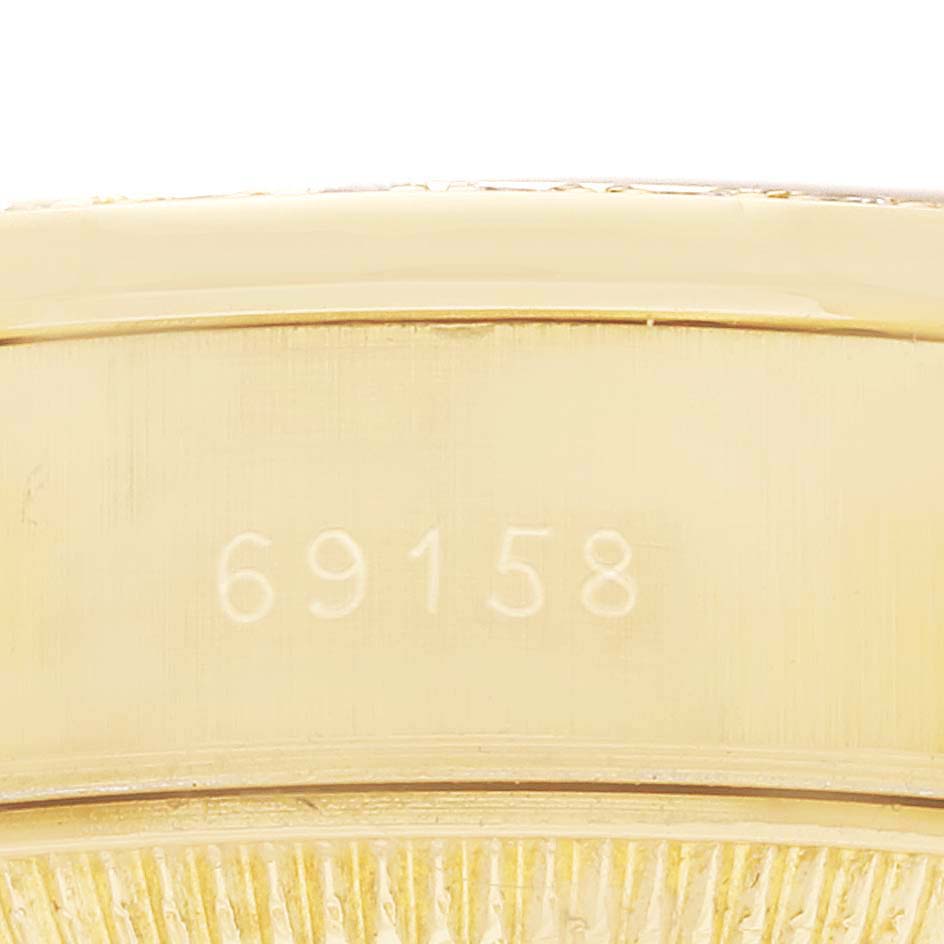 The image shows a close-up of the Rolex President 69158 Women
s Yellow Gold Grey Dial model
s gold clasp with engraved numbers "69158."
