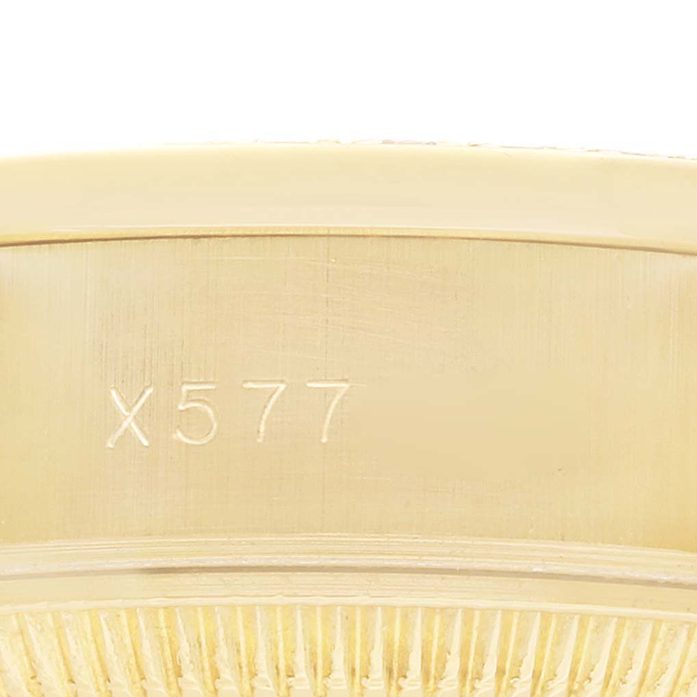 The image shows a close-up of the side of a Rolex President 69158 Women
s Yellow Gold Grey Dial watch, highlighting an engraved serial number.