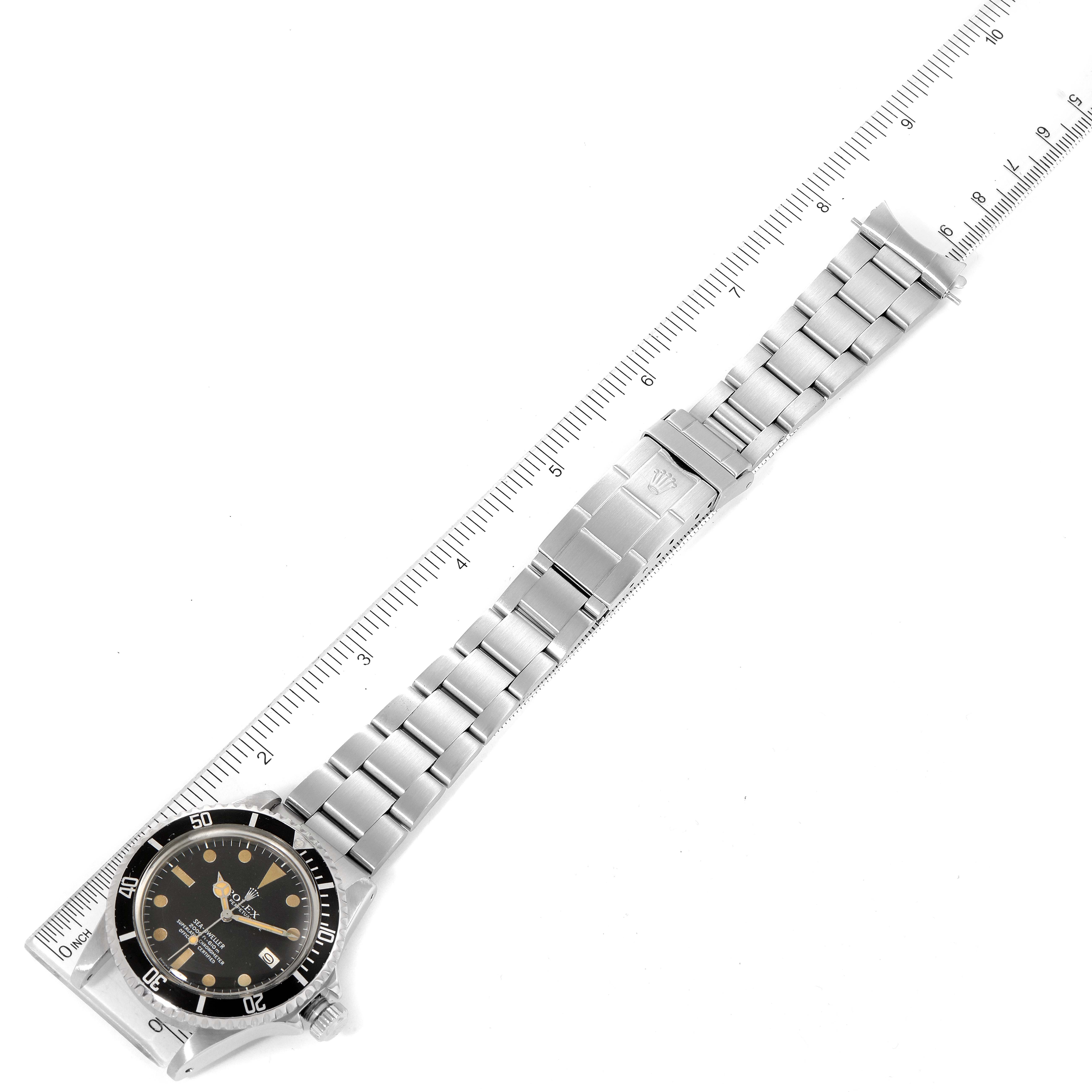 The image shows a Rolex Vintage Collection 1665 Men's Stainless Steel Black Dial 1665 Men's Stainless Steel Black Dial watch laid flat with its stainless steel bracelet fully extended, next to a ruler.