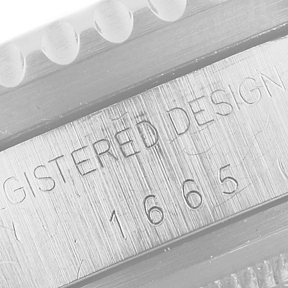 A close-up of the edge of the Rolex Vintage Collection 1665 Men's Stainless Steel Black Dial 1665 Men's Stainless Steel Black Dial model 1665 showing engravings and part of the bezel.