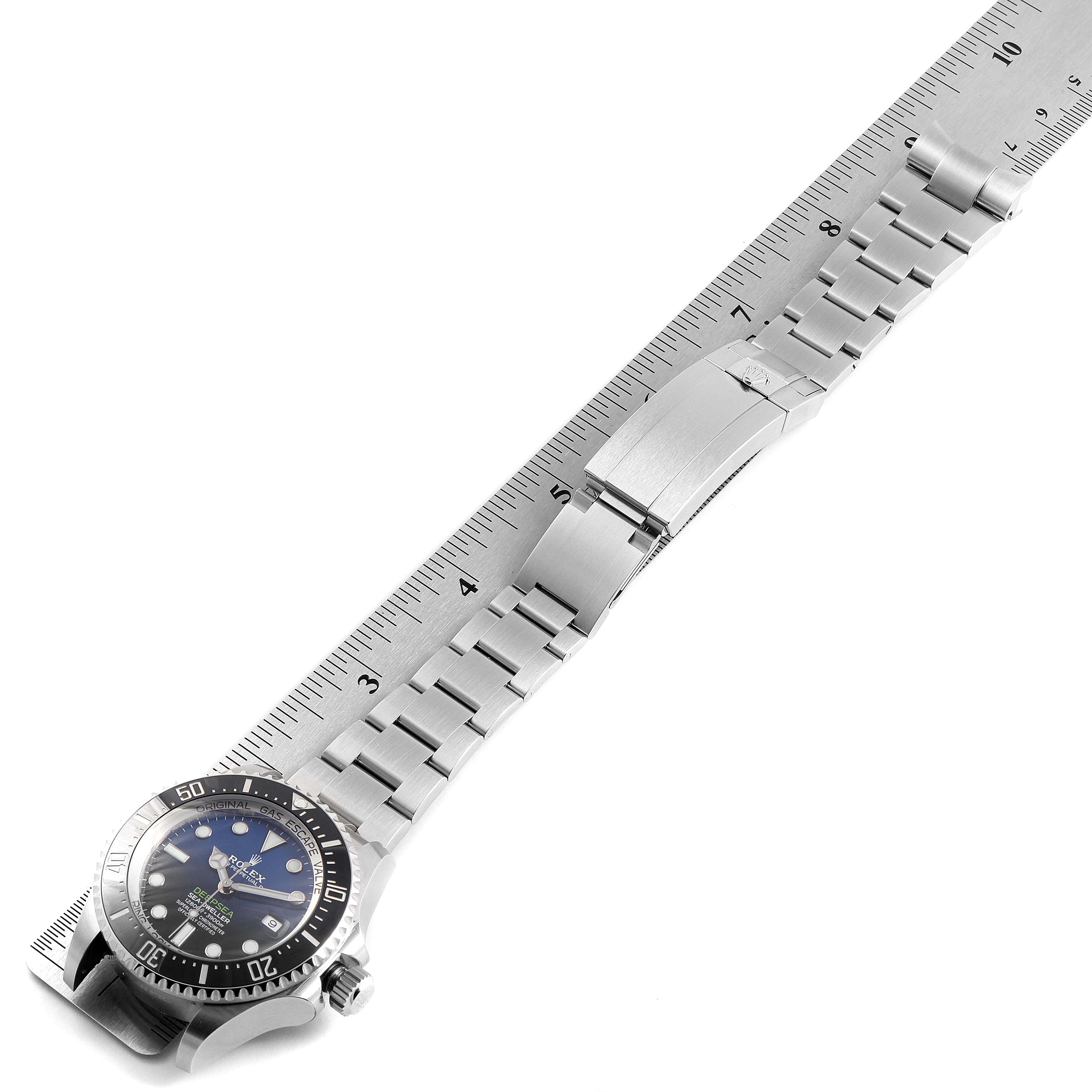 The Rolex Sea-Dweller 126660 Men's Stainless Steel Blue Dial 126660 Men's Stainless Steel Blue Dial watch is shown from an angled top-down perspective, alongside a ruler to measure the bracelet length.