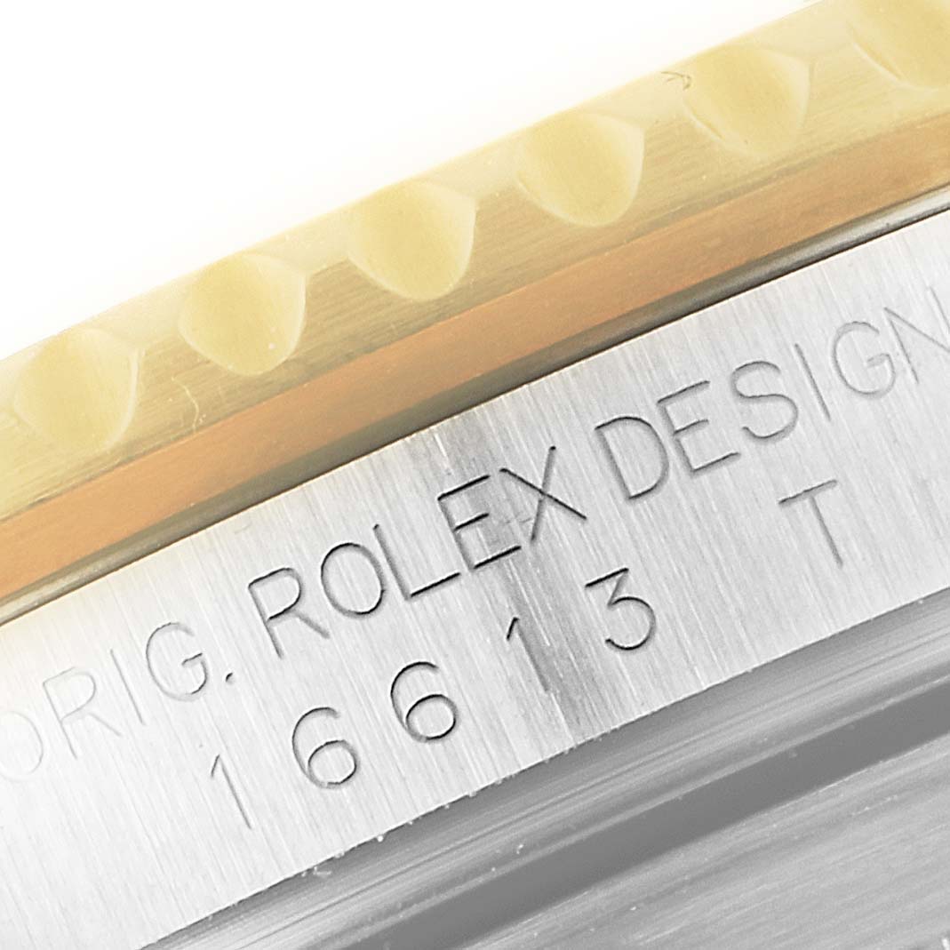 This image shows a close-up of the side bezel and engraved case of a Rolex Submariner 16613 Men
s Steel and Gold (two tone) Grey Dial 16613 Men
s Steel and Gold (two tone) Grey Dial watch.