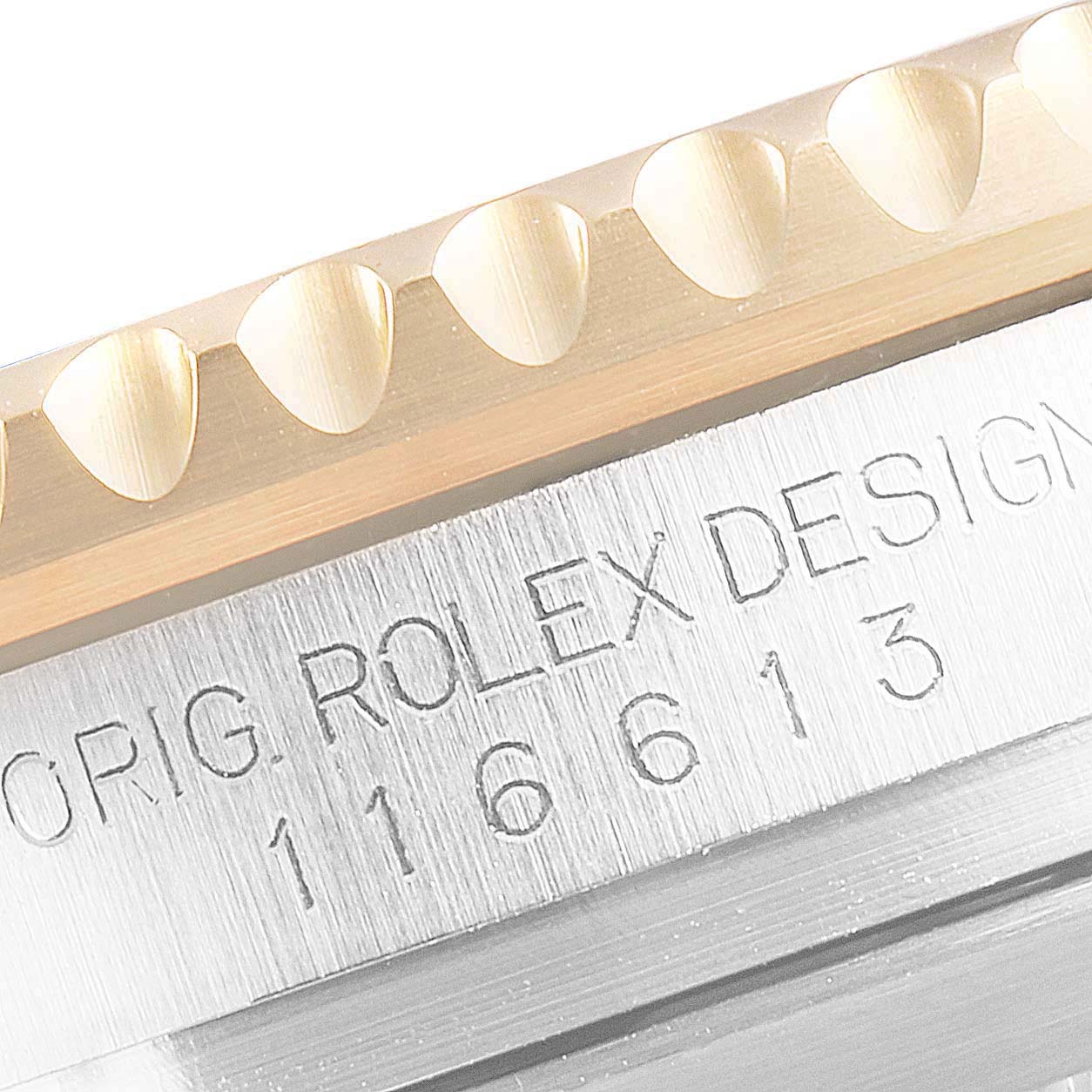 The image shows a close-up of the bezel and case sides of a Rolex Submariner 116613 Men's Steel and Gold (two tone) Black Dial 116613 Men's Steel and Gold (two tone) Black Dial, highlighting the engraved text and knurled bezel edge.