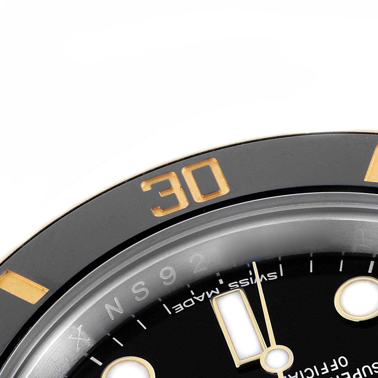 The image shows a close-up of the Rolex Submariner 116613 Men
s Steel and Gold (two tone) Black Dial
s bezel and dial, highlighting the numbers and markers at an angle.