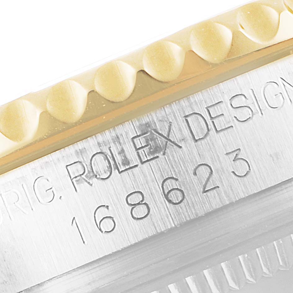 This image shows a close-up of the Rolex Yacht-Master 168623 Men's Steel and Gold (two tone) Grey Dial 168623 Men's Steel and Gold (two tone) Grey Dial model's bezel and engraved side case.