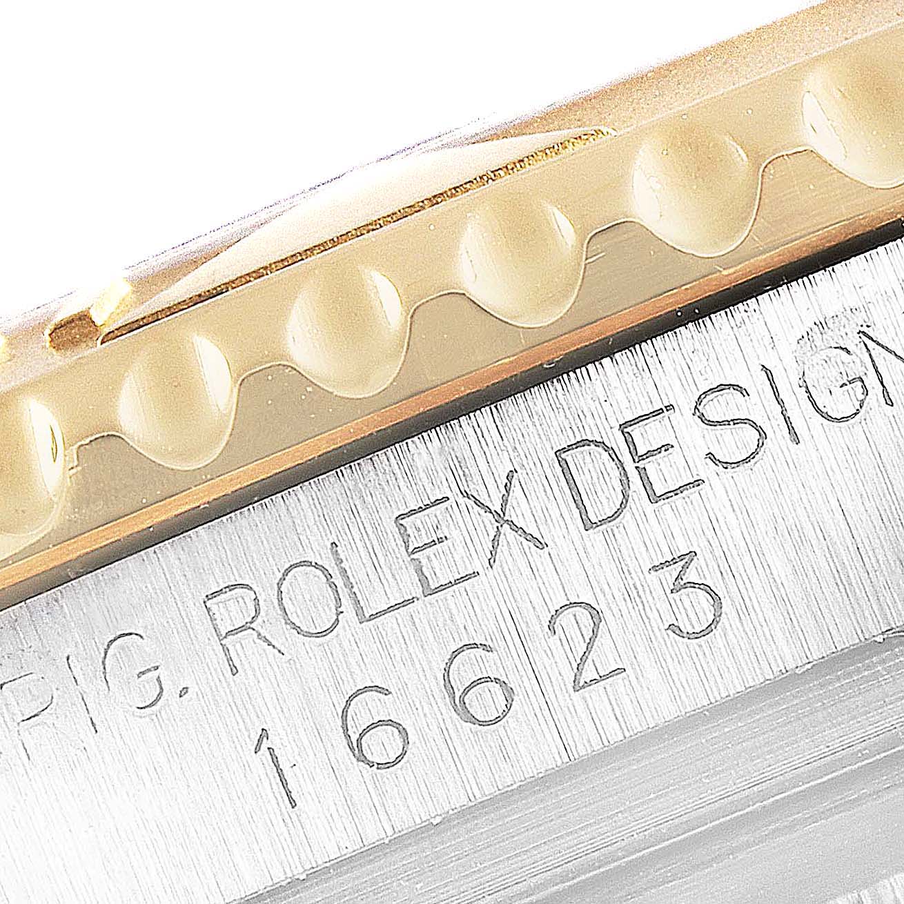 Close-up of the Rolex Yacht-Master 16623 Men's Steel and Gold (two tone) Mother of Pearl Dial 16623 Men's Steel and Gold (two tone) Mother of Pearl Dial bezel and part of the case, showing the model number 16623 engraved.