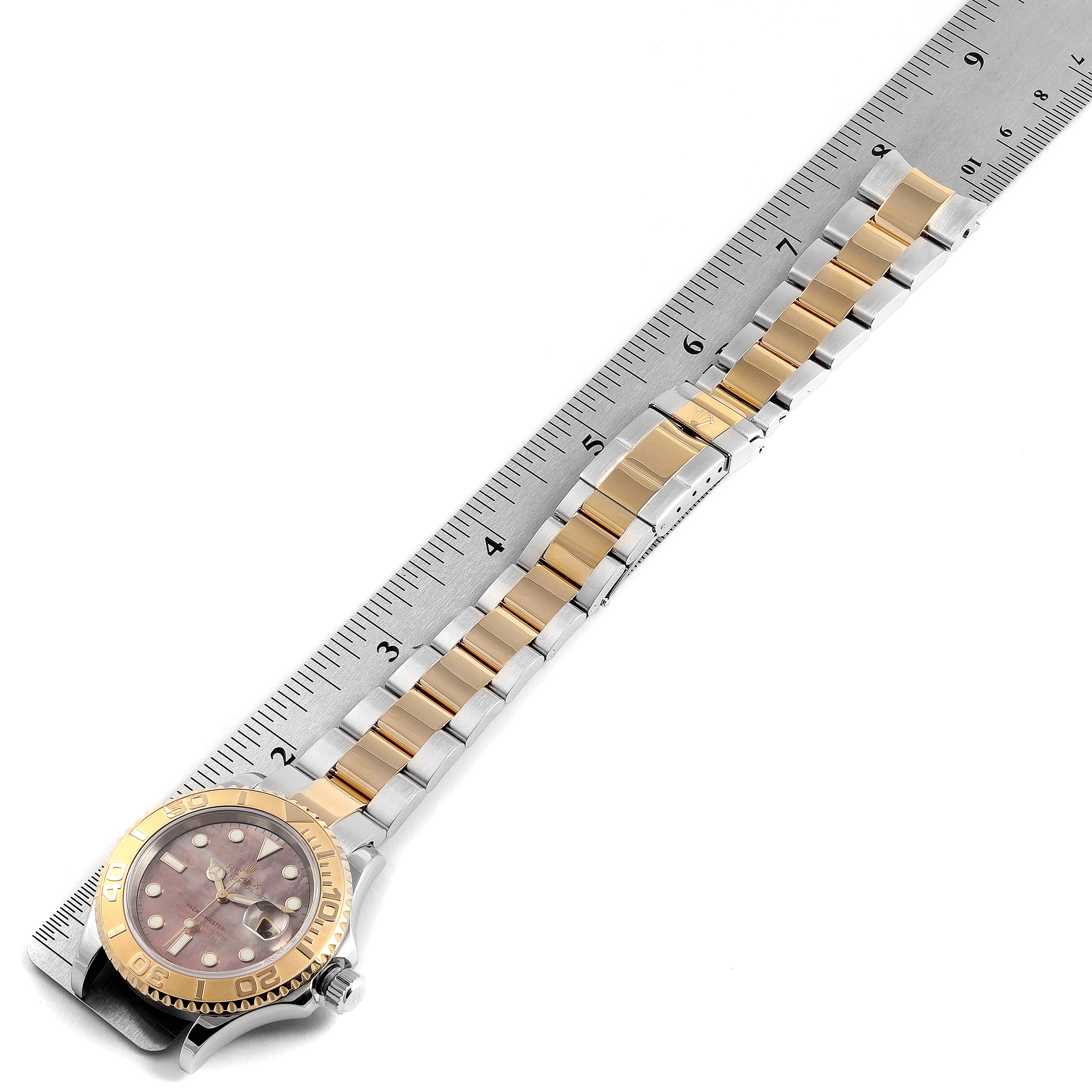 The image shows a top-down view of a Rolex Yacht-Master 16623 Men's Steel and Gold (two tone) Mother of Pearl Dial 16623 Men's Steel and Gold (two tone) Mother of Pearl Dial watch with its band laid alongside a ruler for scale.