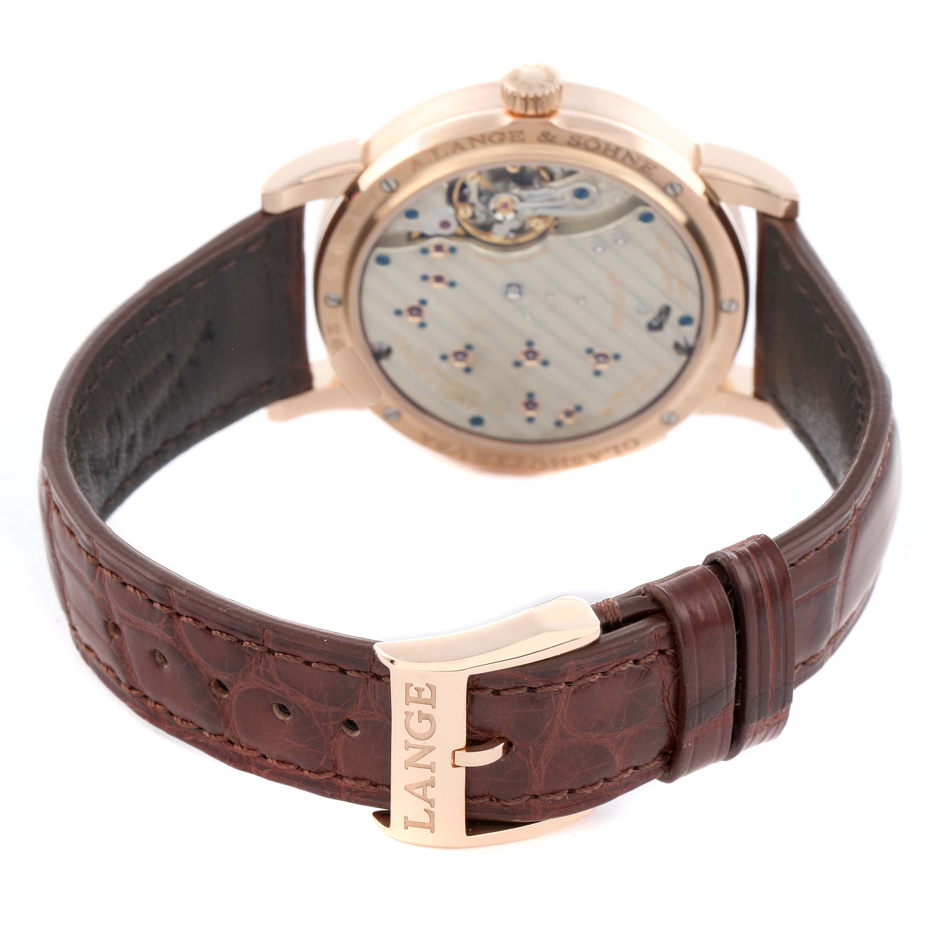 The A. Lange 
Sohne Lange 1 191.032 Men
s Rose Gold Silver Dial watch is shown from the rear, highlighting the open caseback and leather strap with "LANGE" on the clasp.