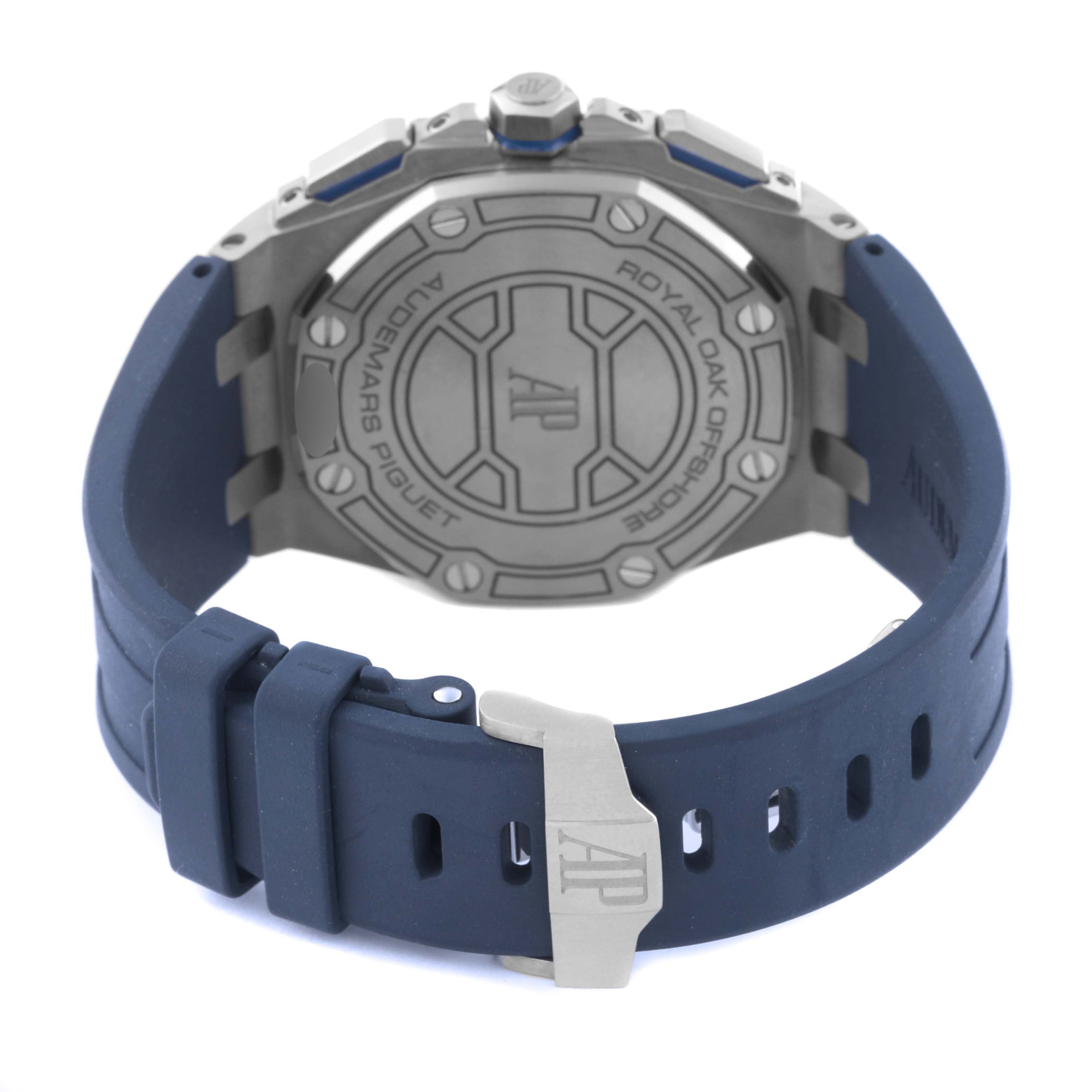 The image shows the back of an Audemars Piguet Royal Oak 26480TI.OO.A027CA.01 Men's Titanium Blue Dial 26480TI.OO.A027CA.01 Men's Titanium Blue Dial watch, highlighting its case back and blue strap with a buckle.