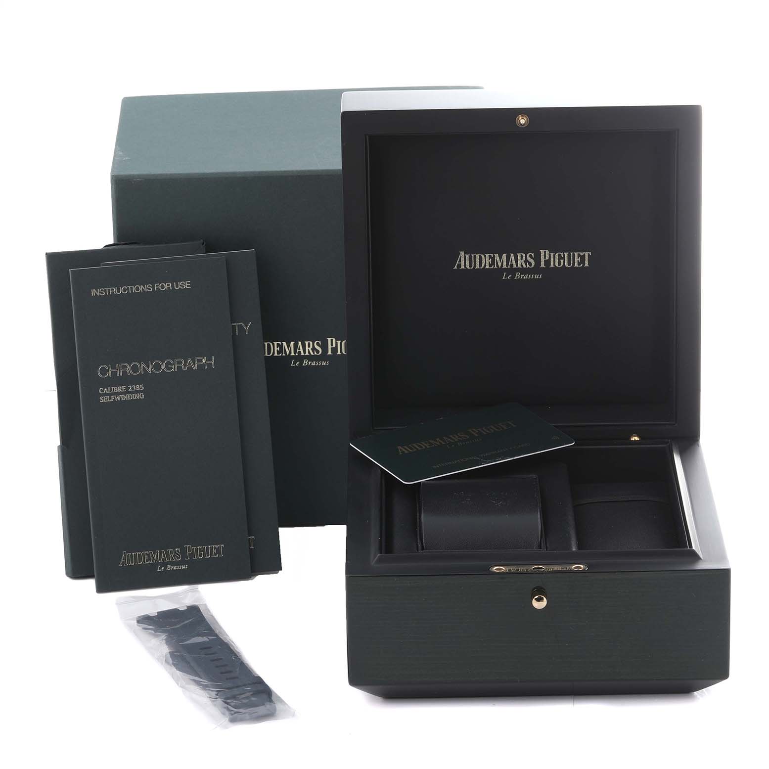 The image shows the packaging, instruction manuals, and extra strap components for the Audemars Piguet Royal Oak 26480TI.OO.A027CA.01 Men's Titanium Blue Dial 26480TI.OO.A027CA.01 Men's Titanium Blue Dial watch.