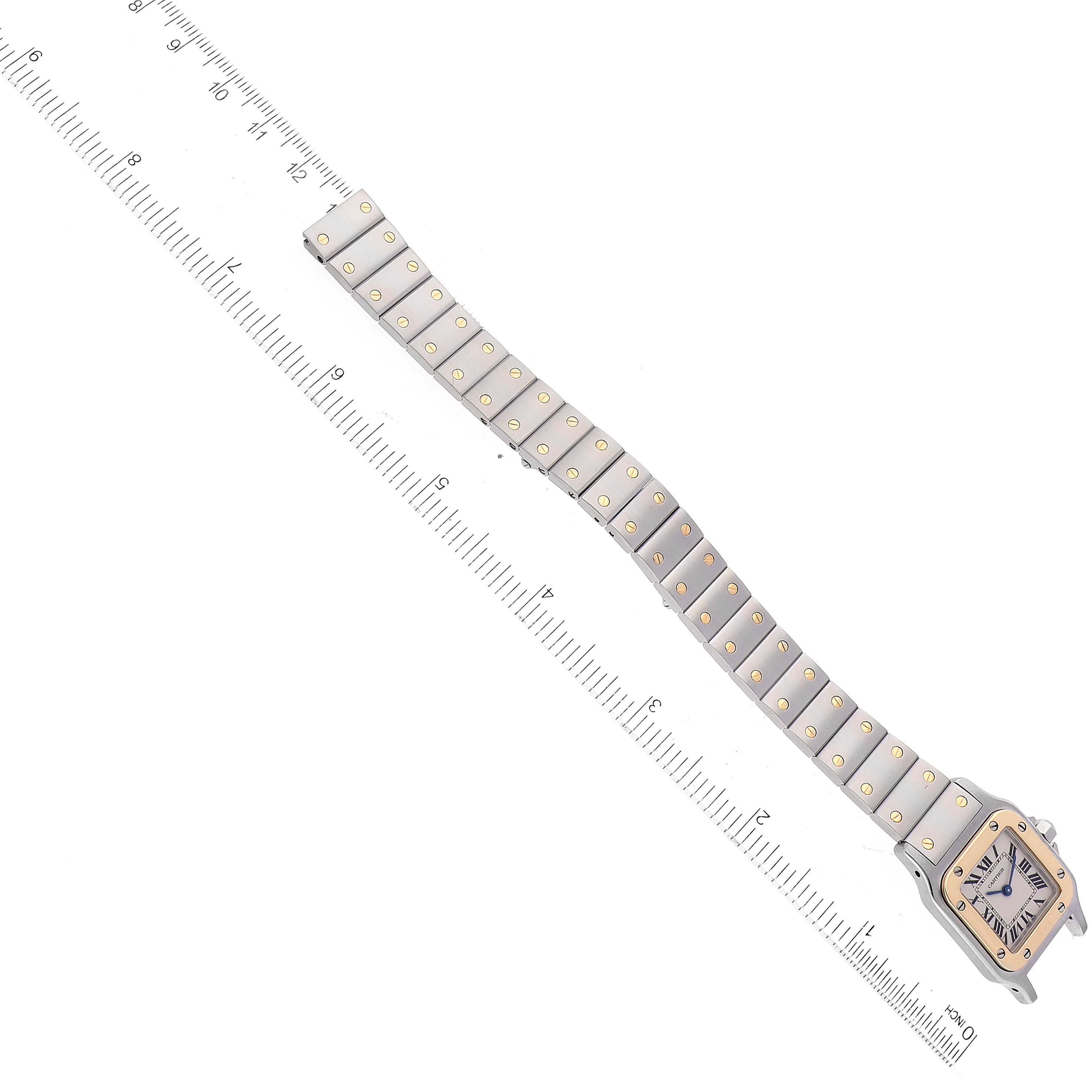 The image shows a top-down view of a Cartier Santos W20012C4 Women's Stainless Steel Silver Dial W20012C4 Women's Stainless Steel Silver Dial watch with most of its bracelet and a ruler for scale.