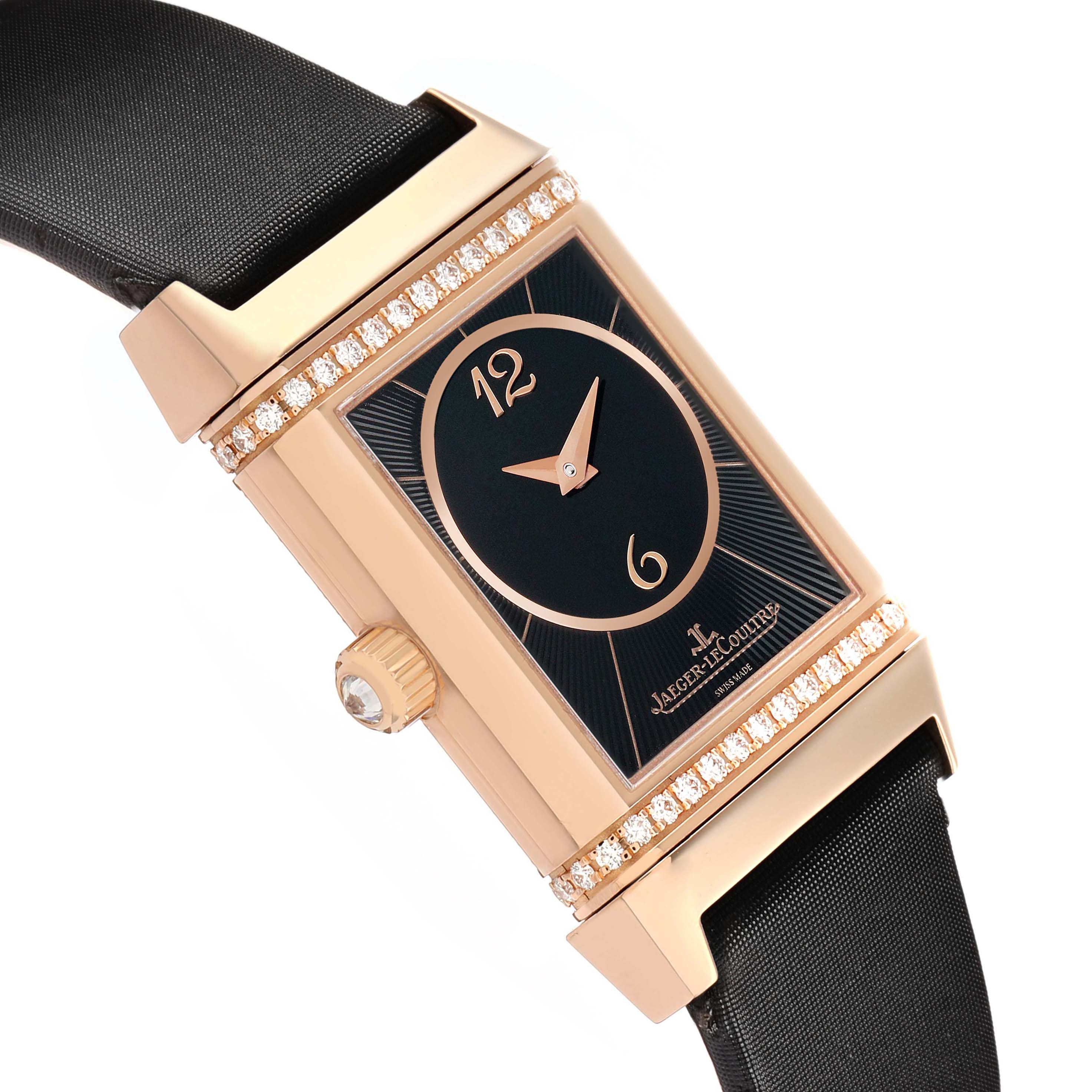 The image features a Jaeger-LeCoultre Reverso watch, showing its rectangular face, crown, strap, and diamond-set case from a tilted angle.