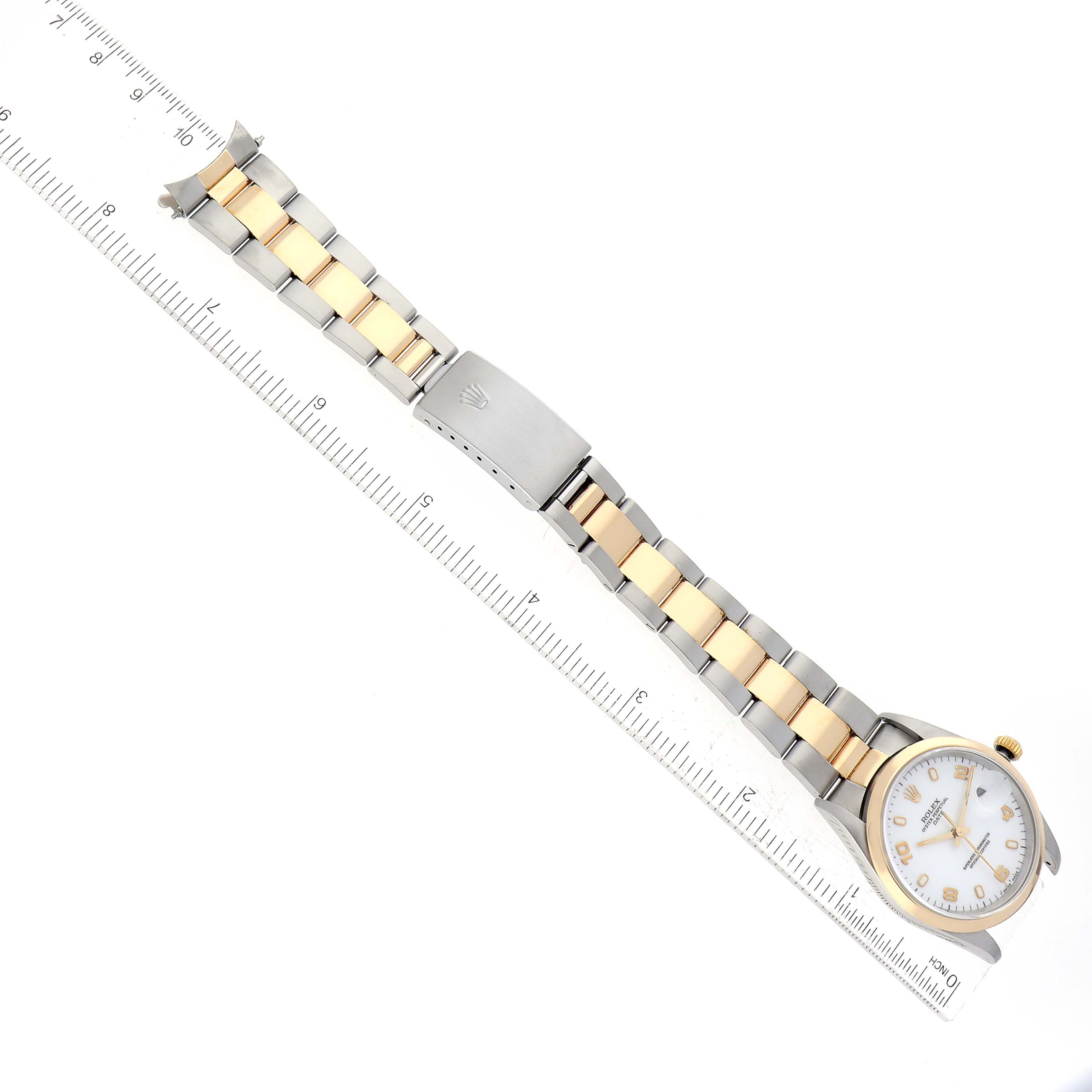 The image shows a Rolex Date 15203 Men's Steel and Gold (two tone) White Dial 15203 Men's Steel and Gold (two tone) White Dial model watch laid flat with ruler measurements alongside, displaying the face, bracelet, and clasp.