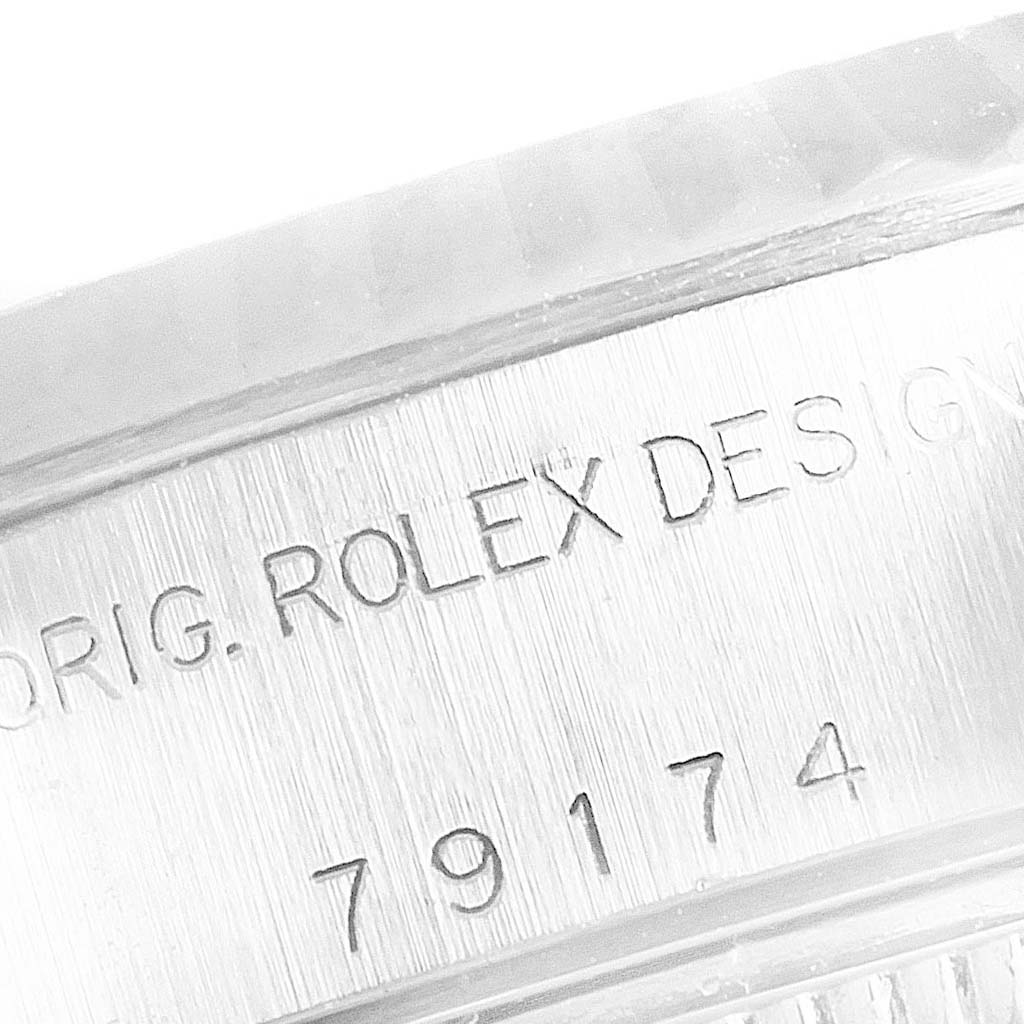 The image shows an extreme close-up of the engraved serial number and "ROLEX" label on the Rolex Datejust 79174 Women's Stainless Steel Silver Dial 79174 Women's Stainless Steel Silver Dial watch casing.