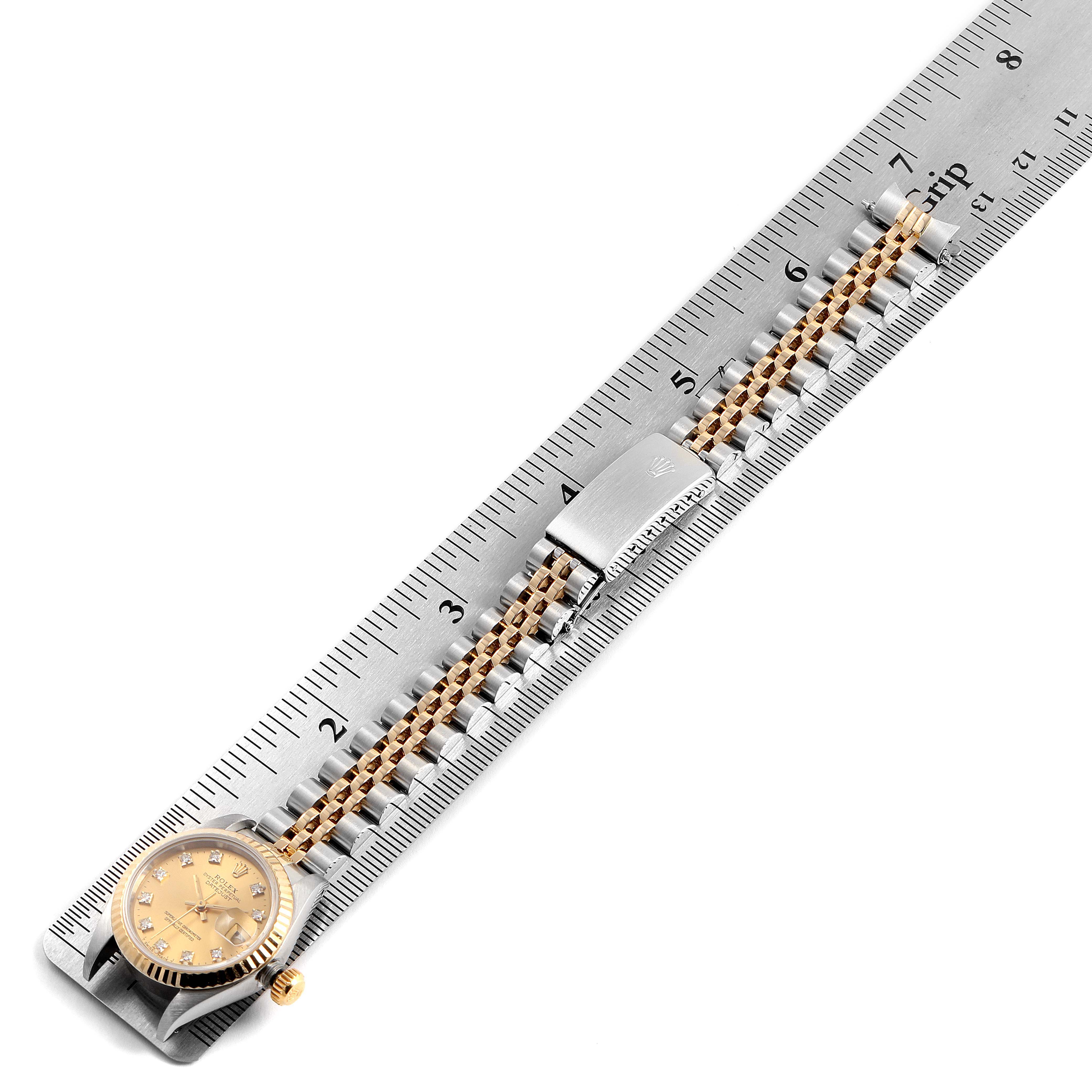 The image shows the Rolex Datejust 69173 Women's Steel and Gold (two tone) Champagne Dial 69173 Women's Steel and Gold (two tone) Champagne Dial watch laid flat with its bracelet extended and measured by a metal ruler.