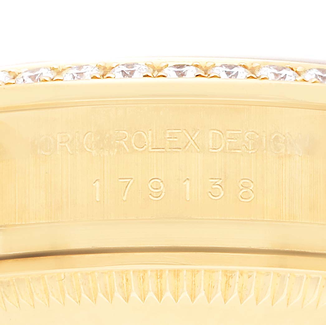 The image shows a close-up of the side of a Rolex Datejust 179138 Women
s Yellow Gold Black Dial watch, highlighting the engraved model number and part of the diamond bezel.