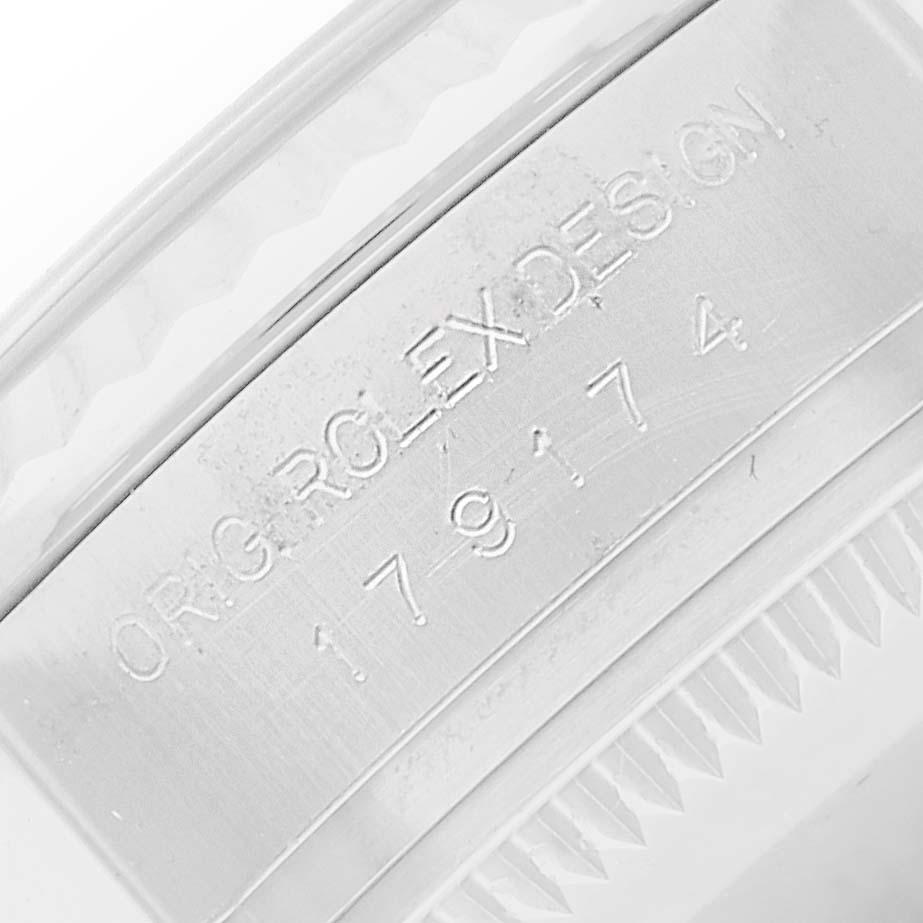 The image shows the engraved side of the bezel of a Rolex Datejust 179174 Women
s Steel and Gold (two tone) Silver Dial, featuring part of the serial number.