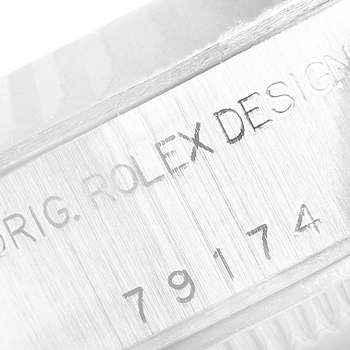 The image shows an engraved case-back of a Rolex Datejust 79174 Women's Stainless Steel Mother of Pearl Dial 79174 Women's Stainless Steel Mother of Pearl Dial model, displaying the serial number and "ORIG. ROLEX DESIGN" text.