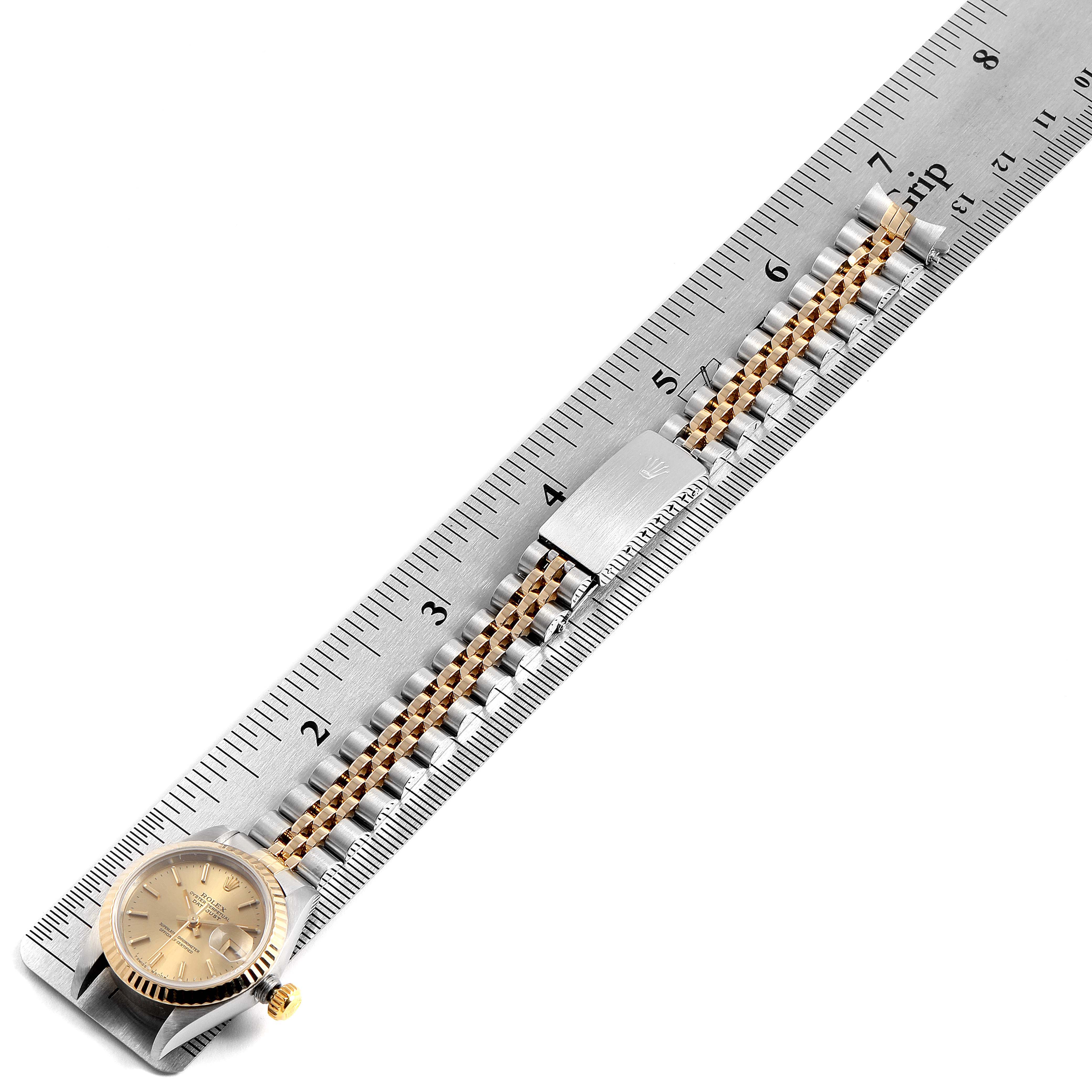 This image shows a Rolex Datejust 69173 Women's Steel and Gold (two tone) Champagne Dial 69173 Women's Steel and Gold (two tone) Champagne Dial watch laid flat with its clasp and band aligned with a ruler for measurement.