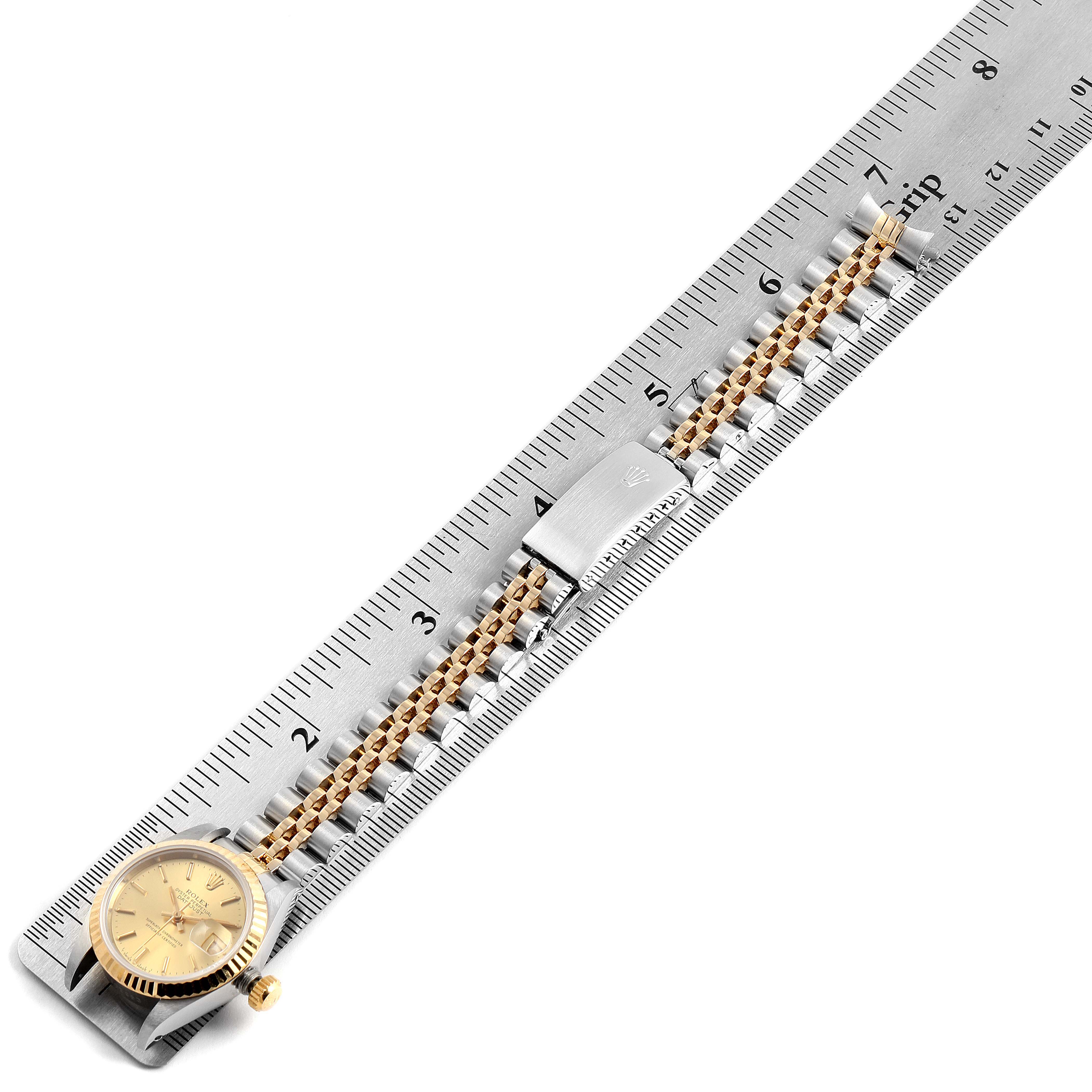 The image shows a Rolex Datejust 69173 Women's Steel and Gold (two tone) Champagne Dial 69173 Women's Steel and Gold (two tone) Champagne Dial watch laid flat on a ruler, displaying its face, bracelet, and clasp.
