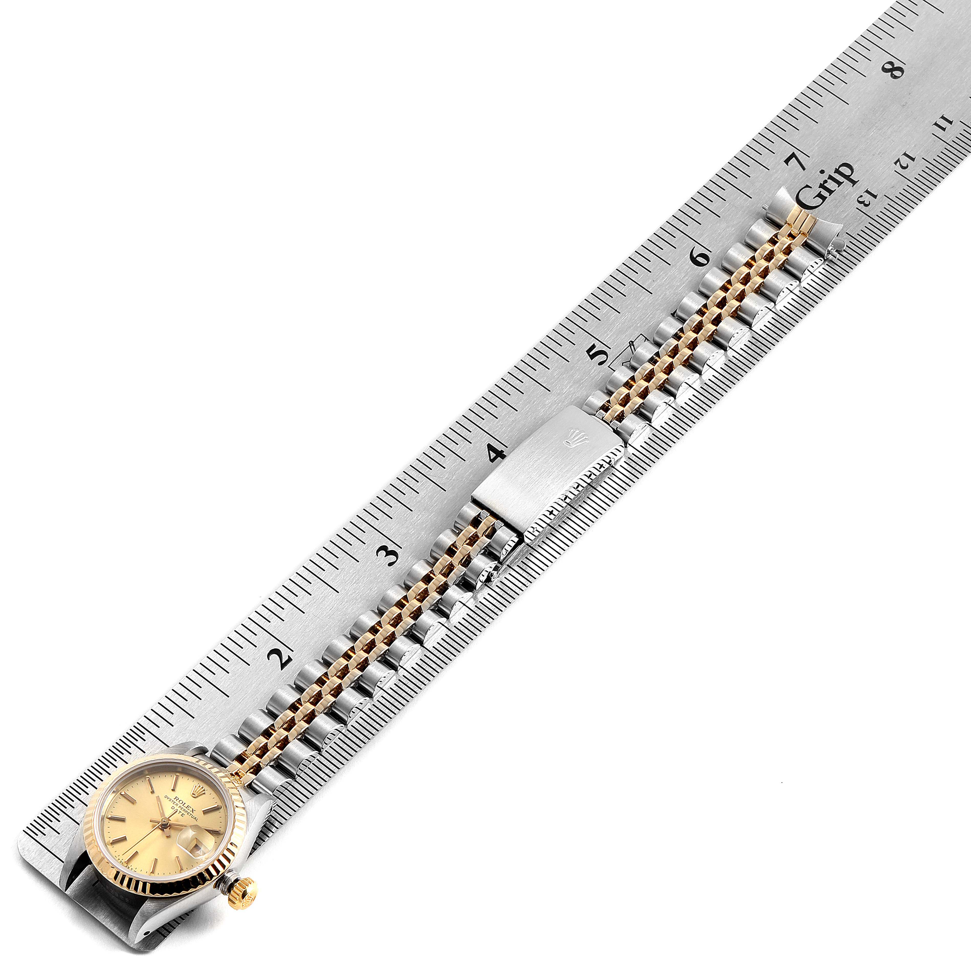 The image shows a Rolex Datejust 69173 Women's Steel and Gold (two tone) Champagne Dial 69173 Women's Steel and Gold (two tone) Champagne Dial watch laying flat on a ruler, displaying the watch face, crown, and part of the bracelet with a clasp.
