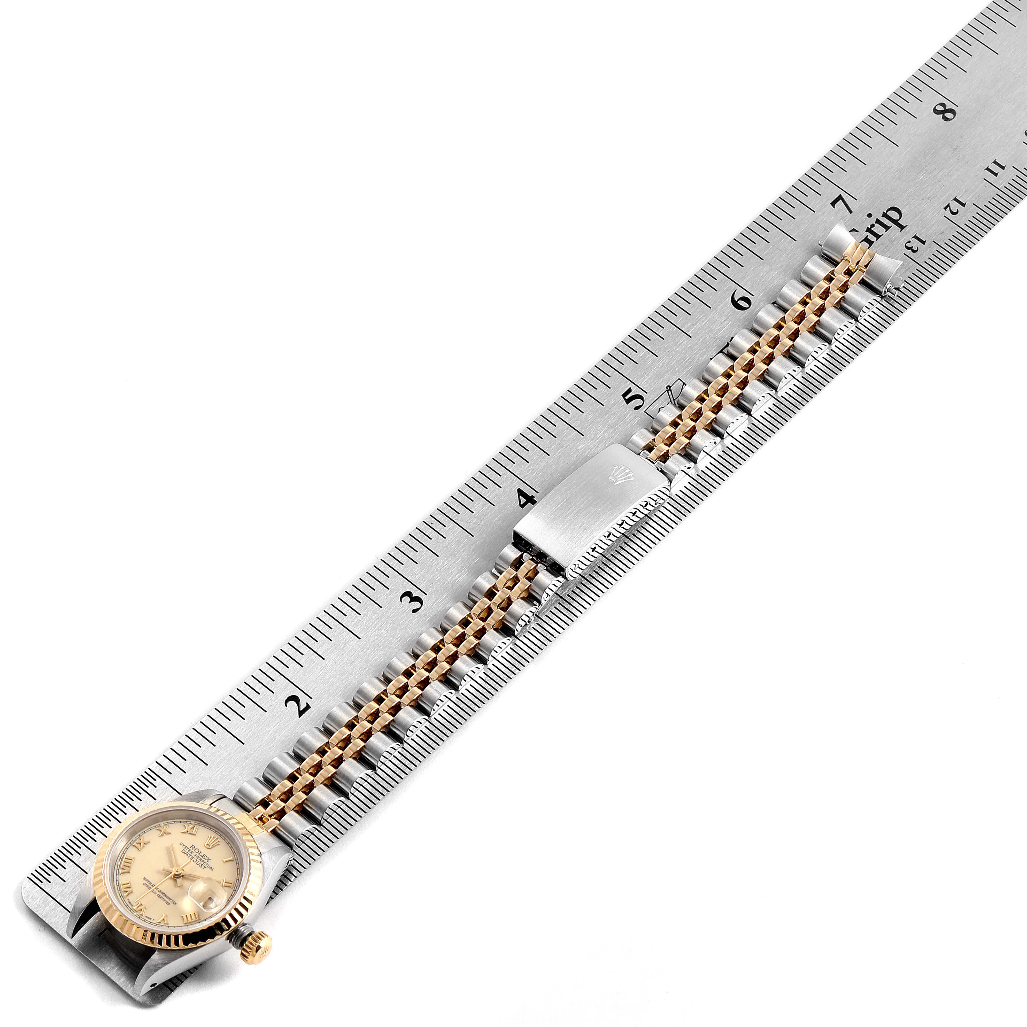 This image shows a Rolex Datejust 69173 Women's Stainless Steel Beige Dial 69173 Women's Stainless Steel Beige Dial watch laid flat on a ruler, displaying its face, bracelet, and clasp from a top-down angle.