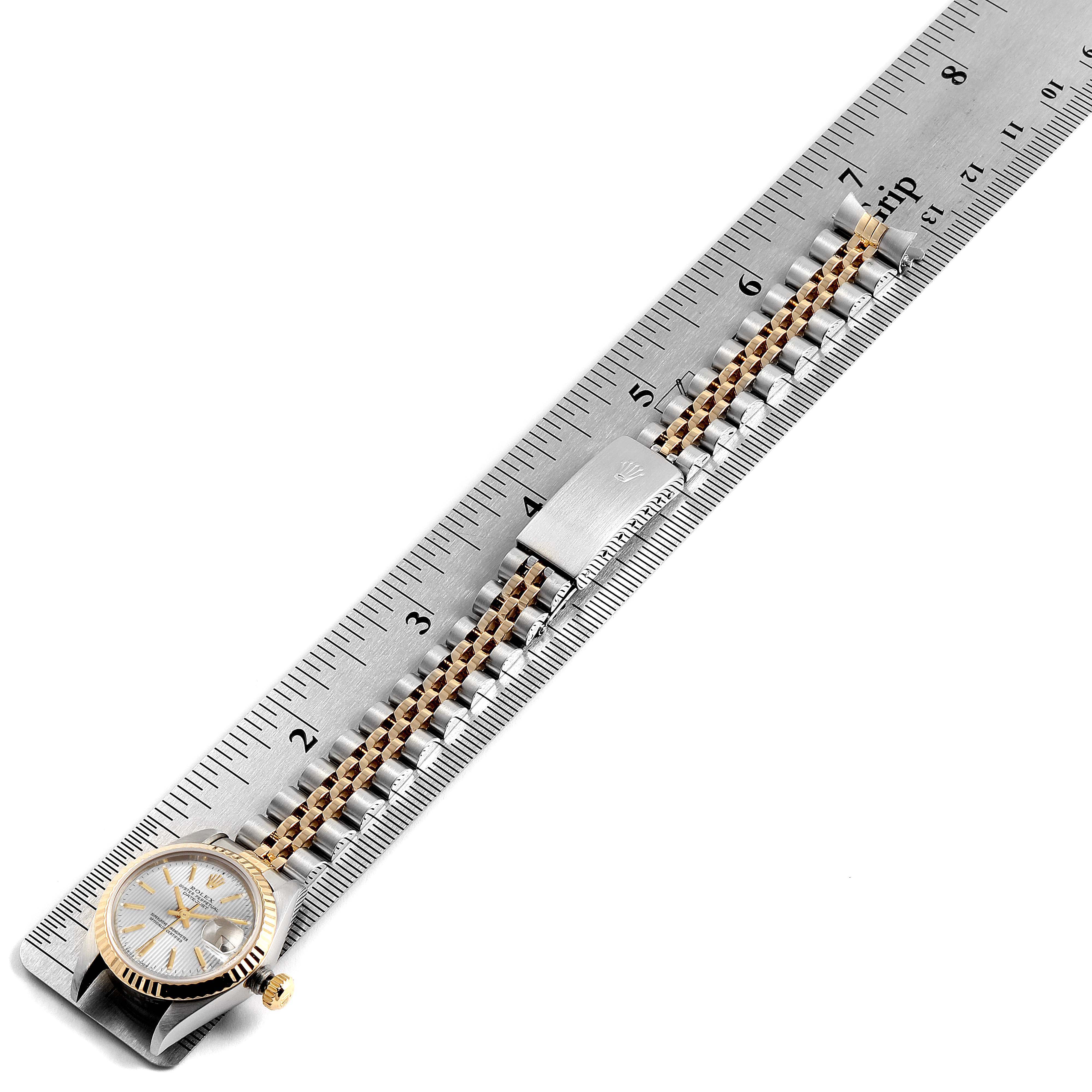 The image shows a side view of the Rolex Datejust 69173 Women's Steel and Gold (two tone) Silver Dial 69173 Women's Steel and Gold (two tone) Silver Dial watch partially open, placed beside a ruler.