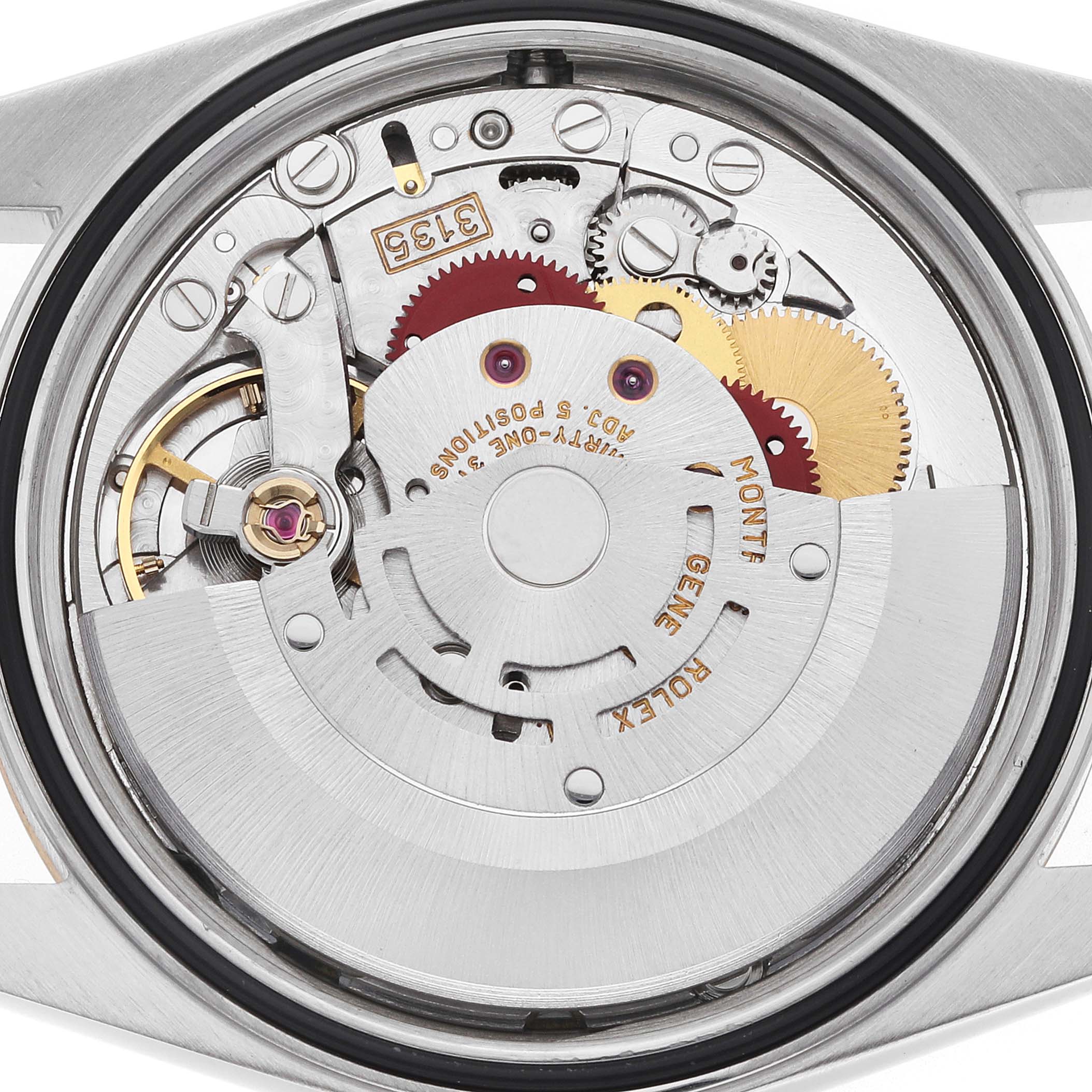 The image shows the movement of a Rolex Datejust 16233 Men
s Steel and Gold (two tone) Blue Dial watch from a rear angle, highlighting gears and mechanical components.