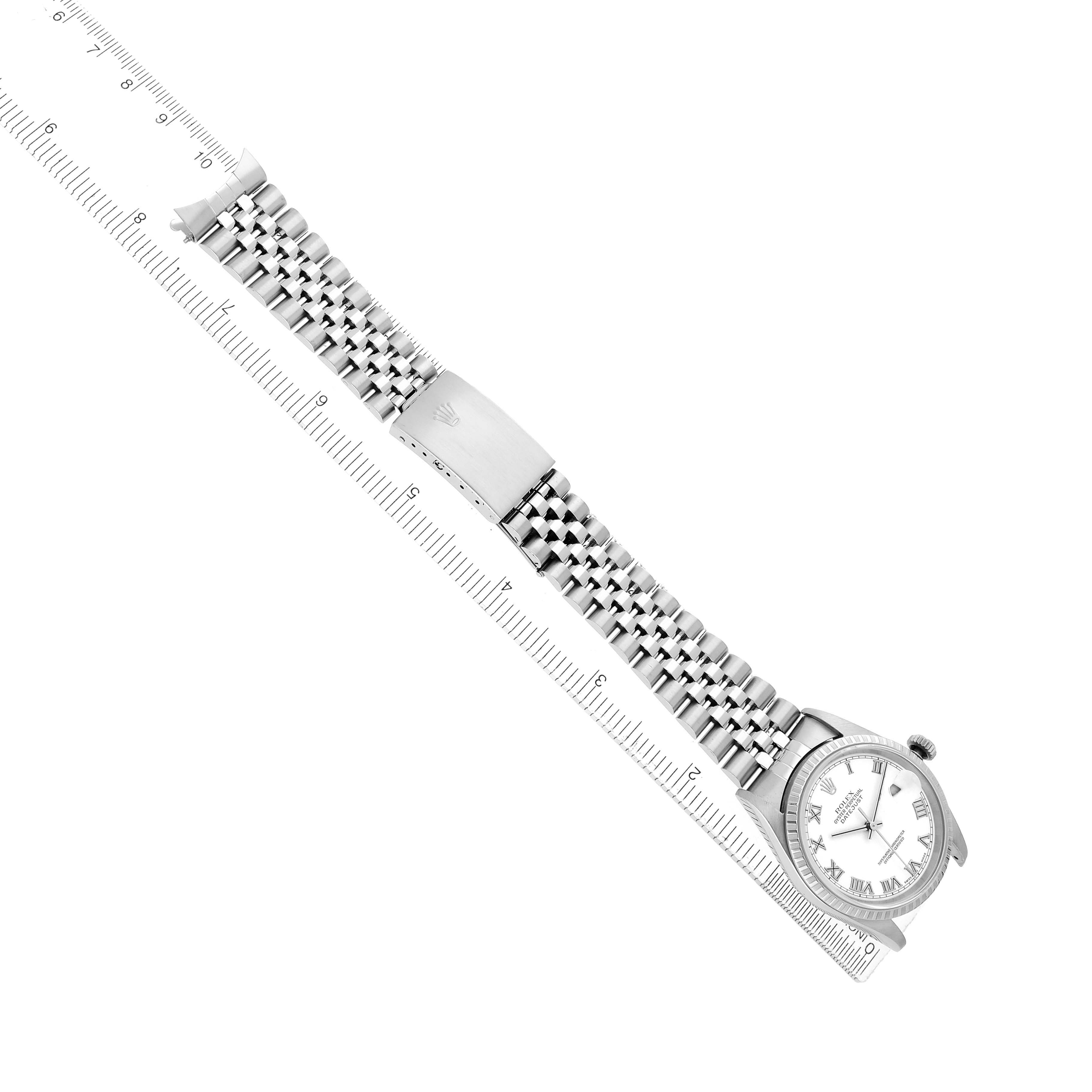 The Rolex Datejust 16220 Men
s Stainless Steel White Dial watch is shown from a top angle, highlighting its bracelet, clasp, and dial alongside a measuring ruler.