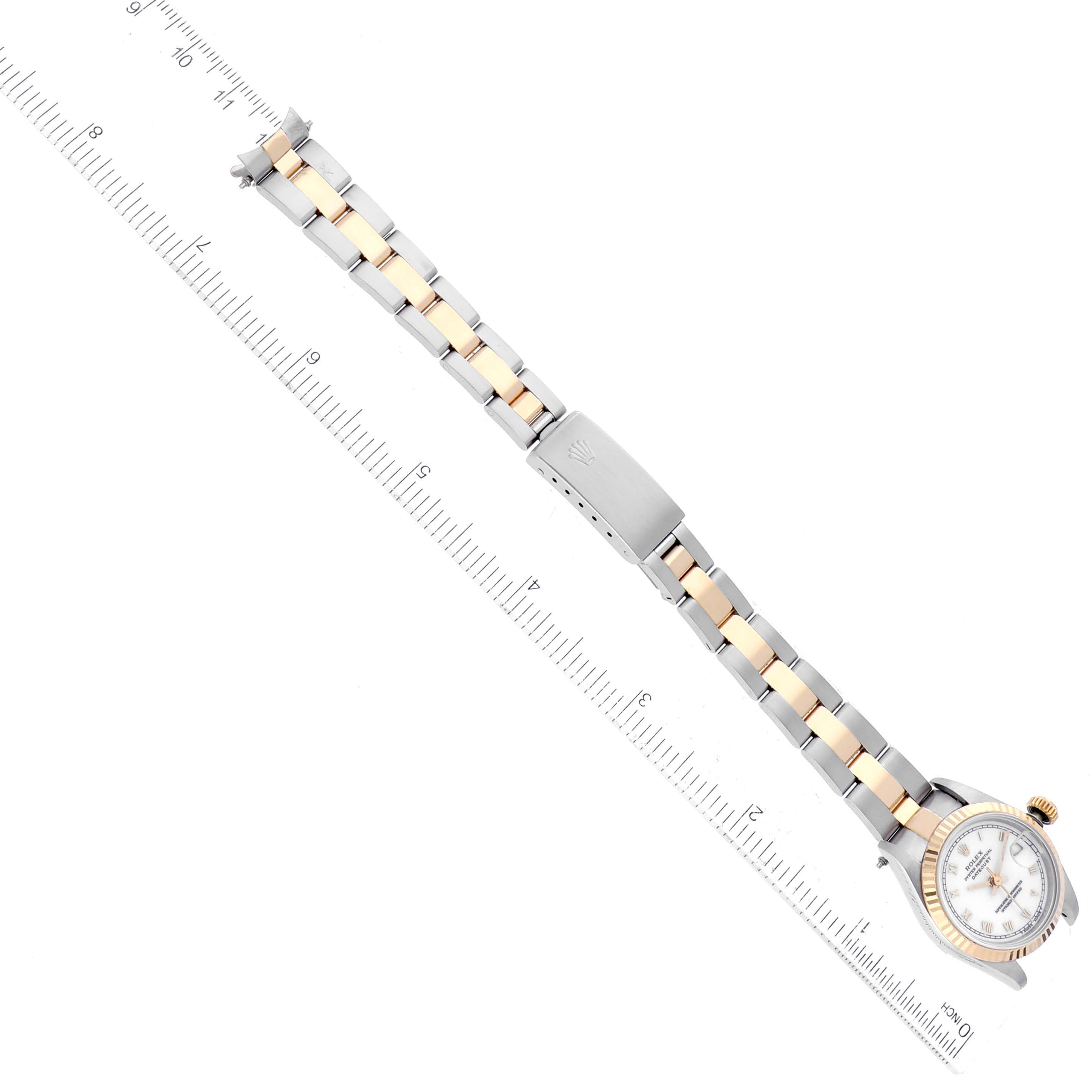 The image shows a top-down view of a Rolex Datejust 69173 Women
s Steel and Gold (two tone) White Dial 69173 Women
s Steel and Gold (two tone) White Dial watch with its bracelet laid out on a ruler.