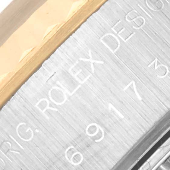 This close-up angle of the Rolex Datejust 69173 Women
s Steel and Gold (two tone) White Dial 69173 Women
s Steel and Gold (two tone) White Dial model shows the engraved branding and model information on its metal case.