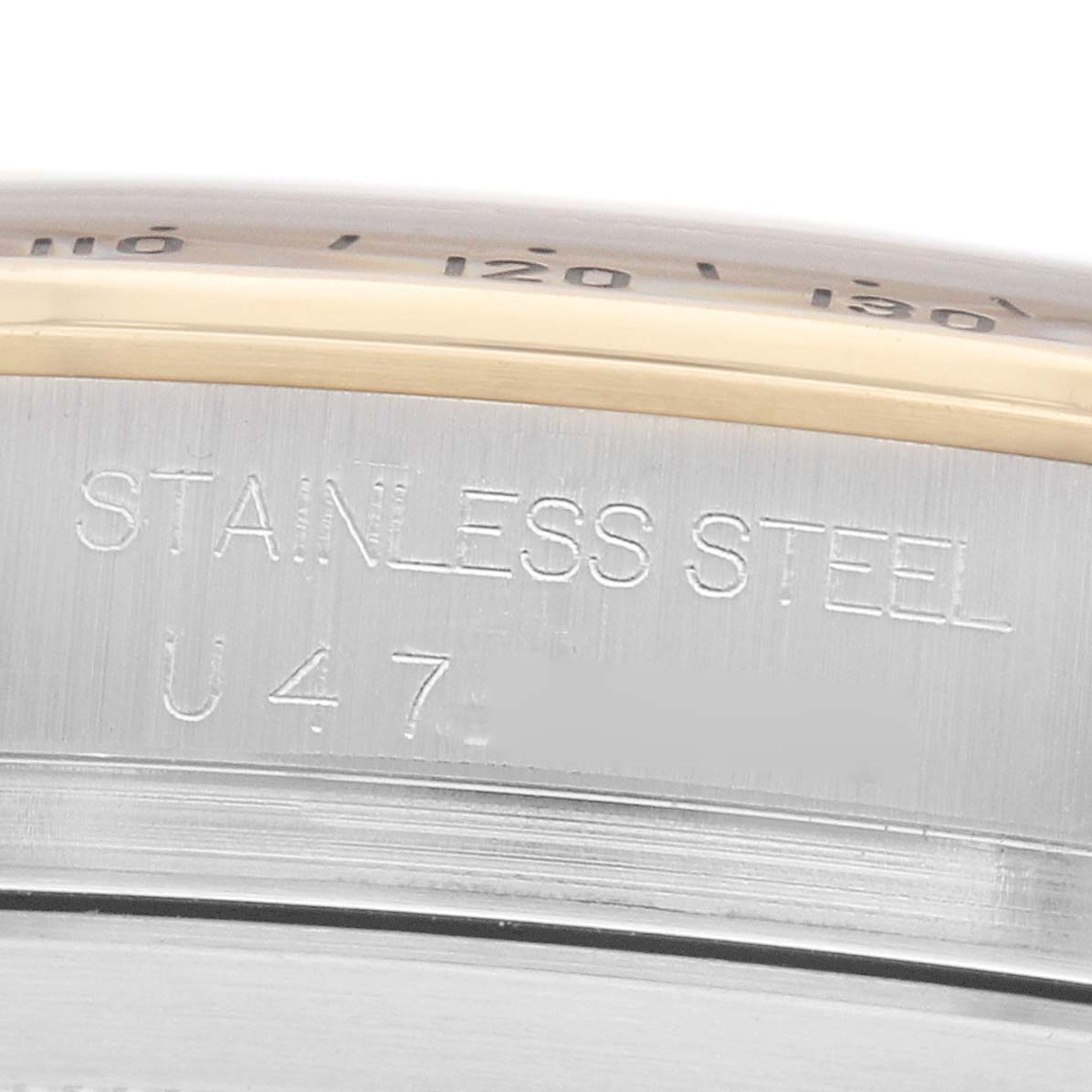 The image shows a close-up side view of the stainless steel case of a Rolex Daytona 16523 Men
s Steel and Gold (two tone) Black Dial, highlighting engravings.